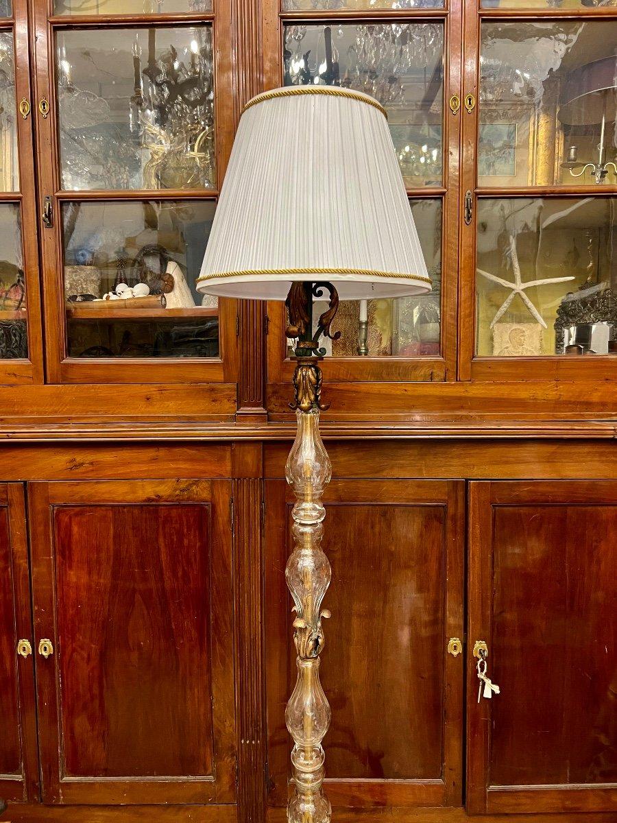 We present you this unique floor lamp crafted from wrought iron with gilded embellishments, featuring a stem in crystal. It follows the distinctive style of Art Deco which emerged in the early 20th century, particularly flourishing in the 1920s and