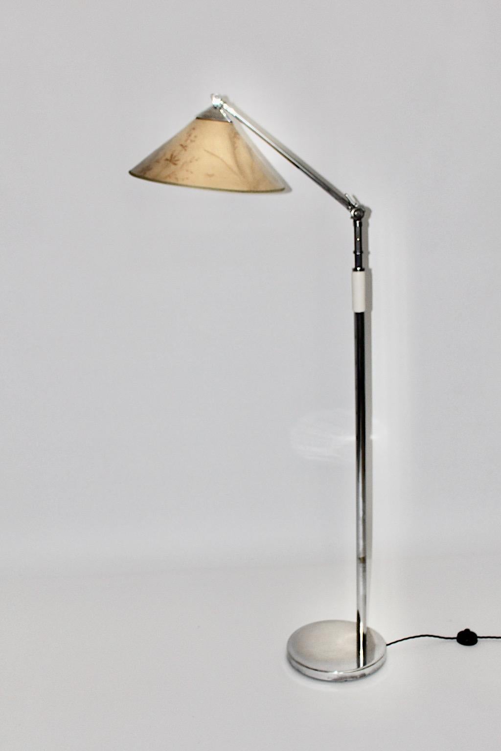 Art Deco Stehlampe von Kaspar & Sic Kunstgewerbe Werkstätte für Metallarbeiten, Wien, 1932 aus vernickeltem Messing, mit weißem Holzgriff und originalem Lampenschirm. Für einen sicheren Stand verfügt er über einen Metallfuß.
Der originelle