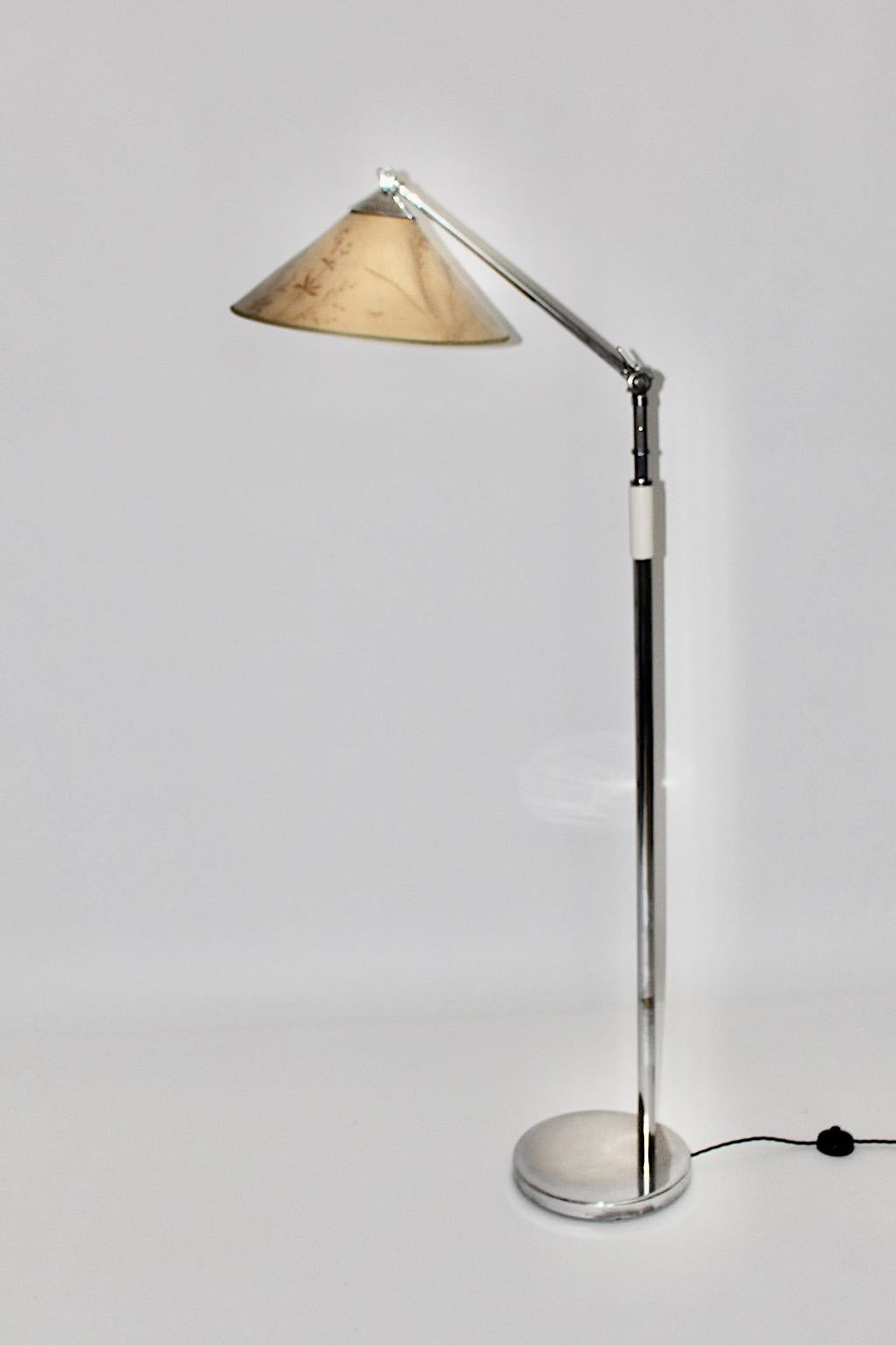 Lampadaire Art déco de Kaspar & Sic Kunstgewerbe Werkstätte für Metallarbeiten, Vienne, 1932 en laiton nickelé, une poignée en bois blanc et un abat-jour original. Pour une stabilité sûre, il est doté d'une base en métal.
L'abat-jour original est en
