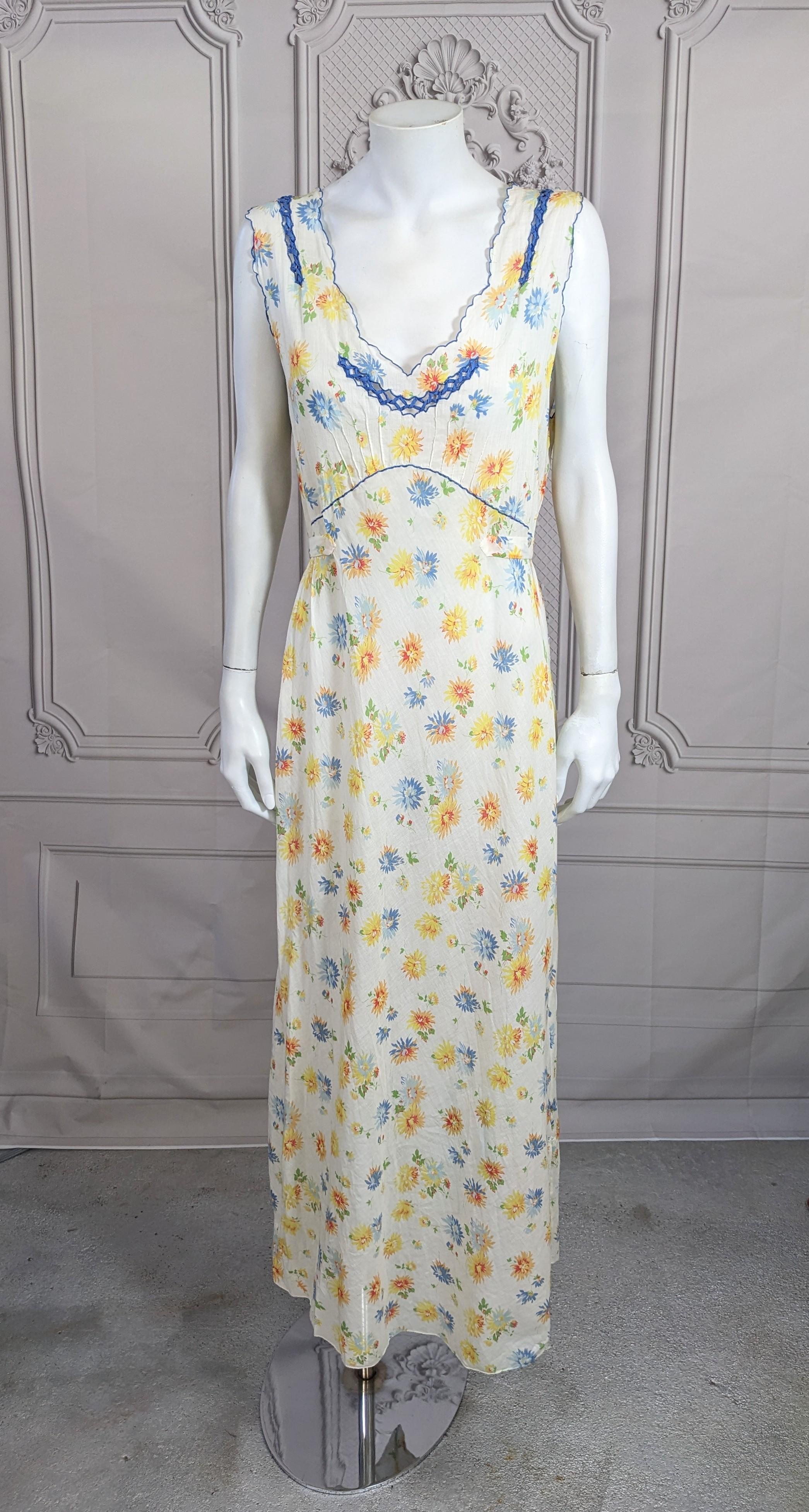 Charming Art Deco Floral Batiste Gown from the 1930's. Soft cotton floral batiste is bias cut with scalloped blue edges, pin tucks and panels of hand made open work blue bias cording. 2 ties at front allow for pulling in the waist area. 1930's USA.