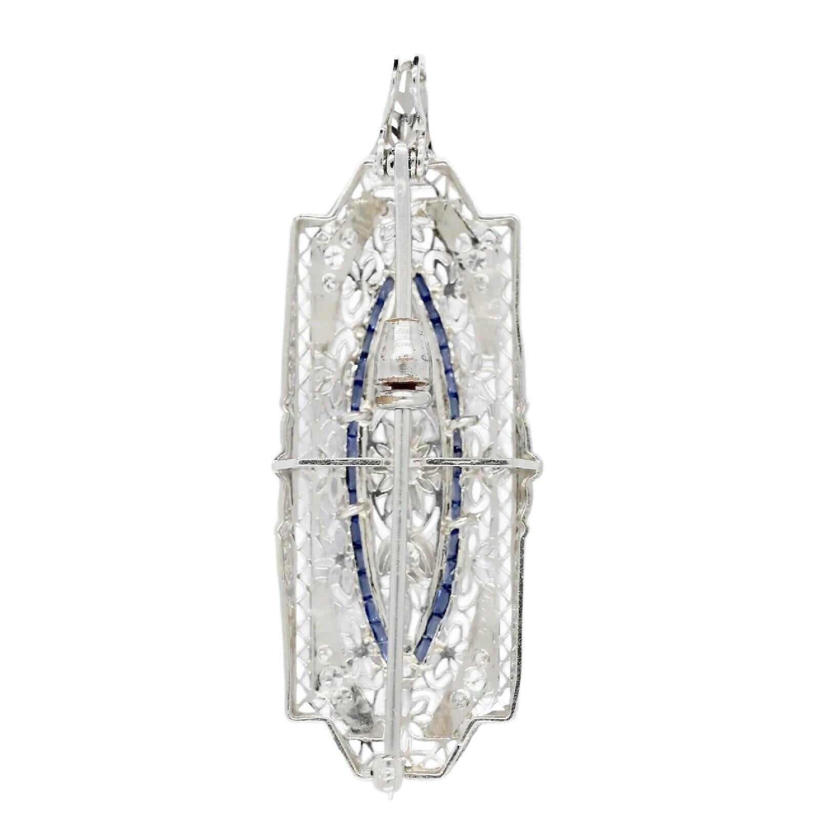 An Art Deco period old European cut diamond, and French cut sapphire filigree pendant.

Set throughout with a total of nineteen diamonds weighing 0.78ctw of G color and VS clarity.

Accented by channel set French cut sapphires and framed by