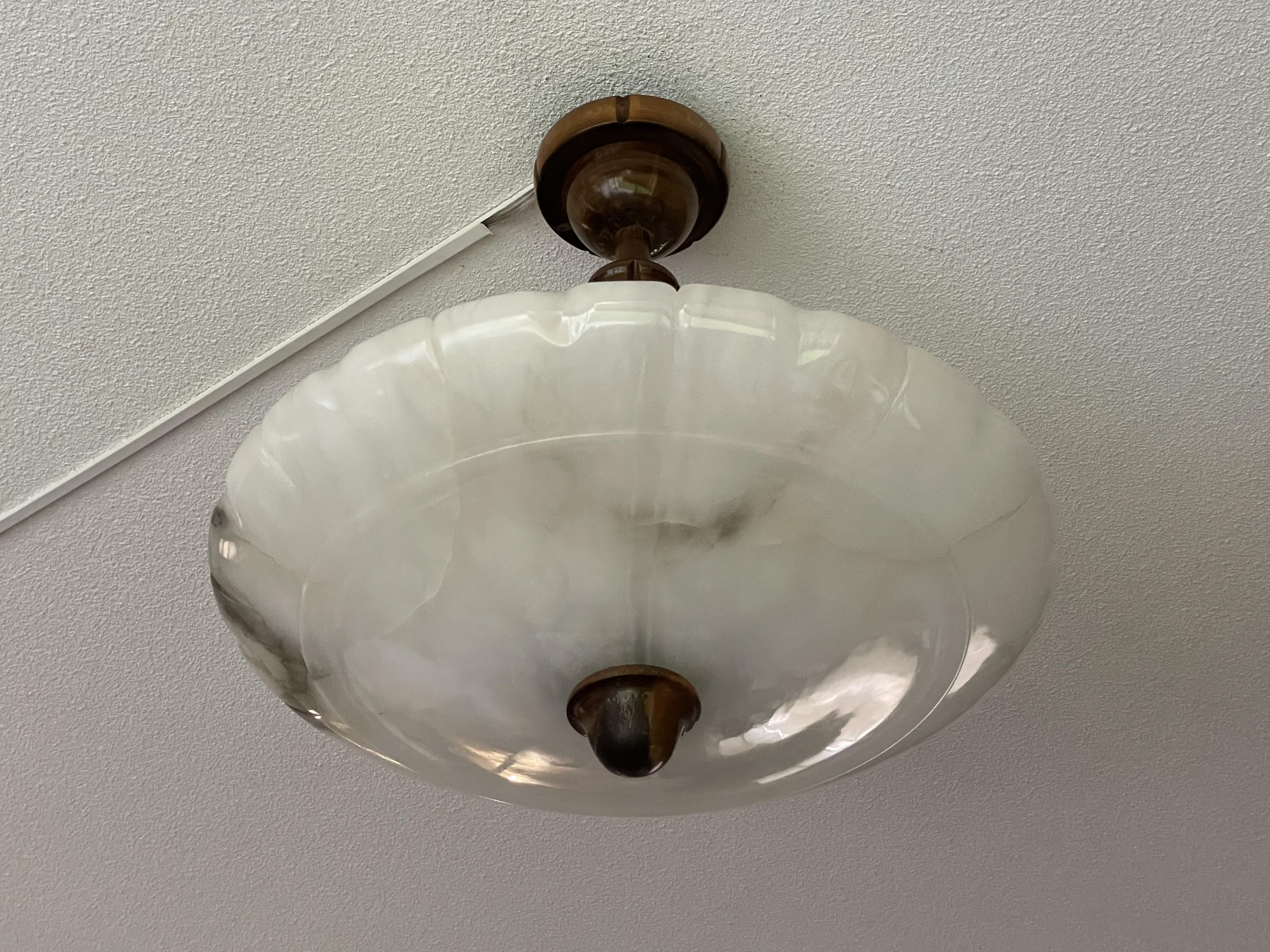 Timeless mineral stone flush mount from the European Art Deco era.

This wonderfully stylish and good size Art Deco light fixture comes with a stunning and superbly polished alabaster shade. What makes this antique shade extra spectacular is the