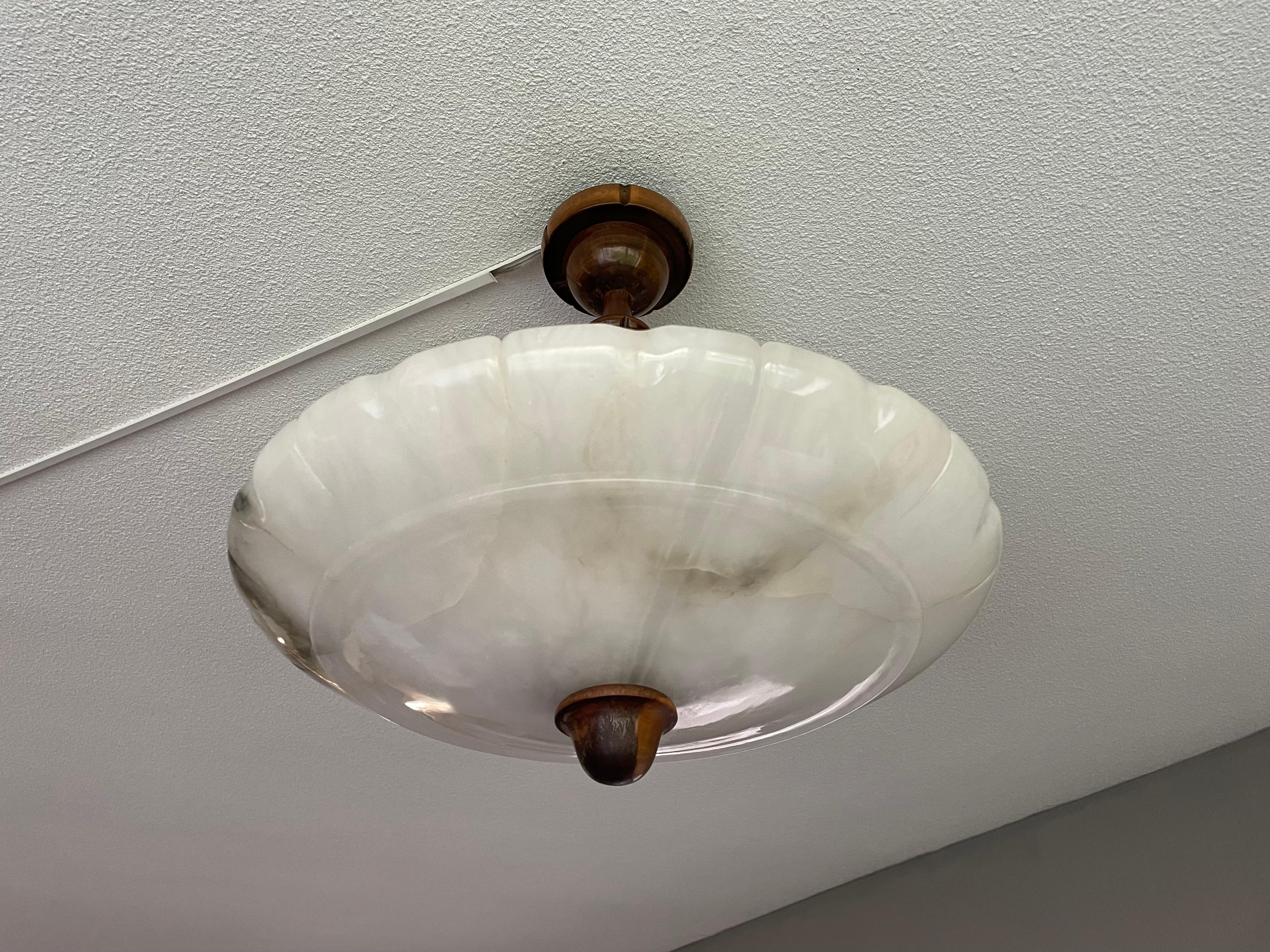 Timeless mineral stone flush mount from the European Art Deco era.

This wonderfully stylish and good size Art Deco light fixture comes with a stunning and superbly polished alabaster shade. What makes this antique shade extra spectacular is the