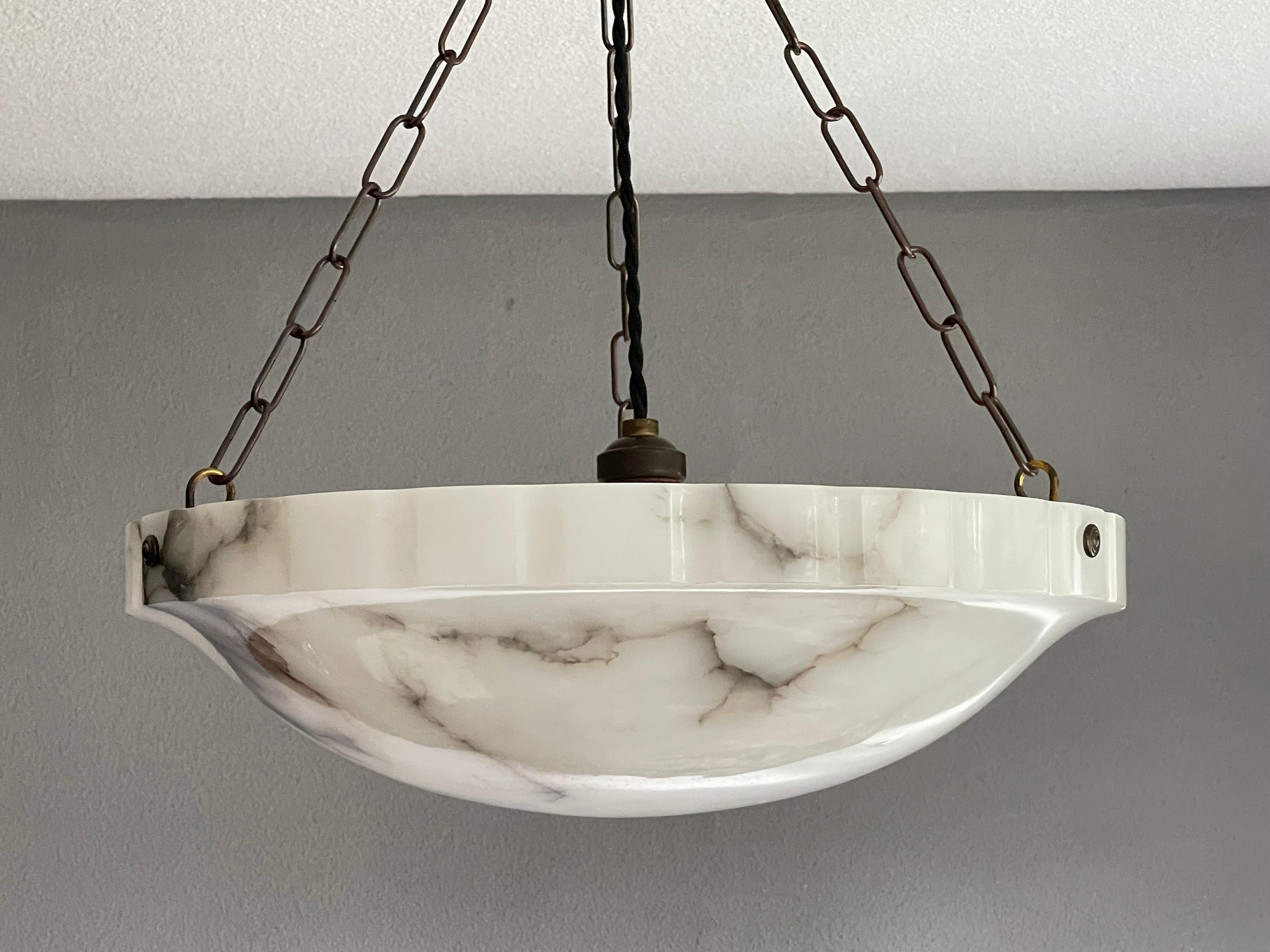 Good size and mint alabaster pendant from the heydays of the Art Deco era.

This rare shape and ideal size Art Deco light fixture comes with a stunning and mint condition, polished alabaster shade. This practical size and striking alabaster shade
