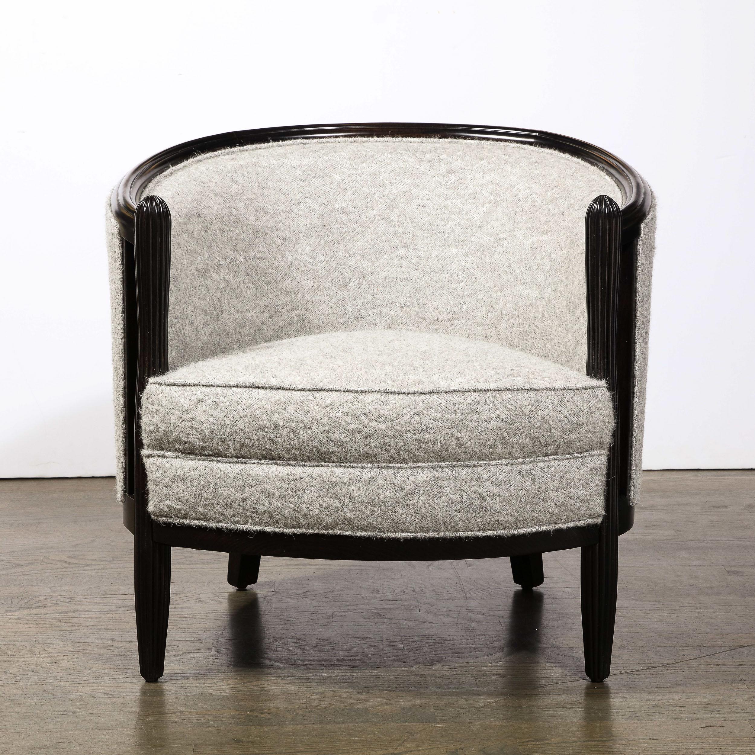 This pair of Art Deco Lounge Chairs in Ebonized Walnut and Holly Hunt Upholstery in the manner of Ruhlman originate from the France, Circa 1930. Featuring a curved back and lovely fluted detailing in the ebonized frame and supports, these chairs