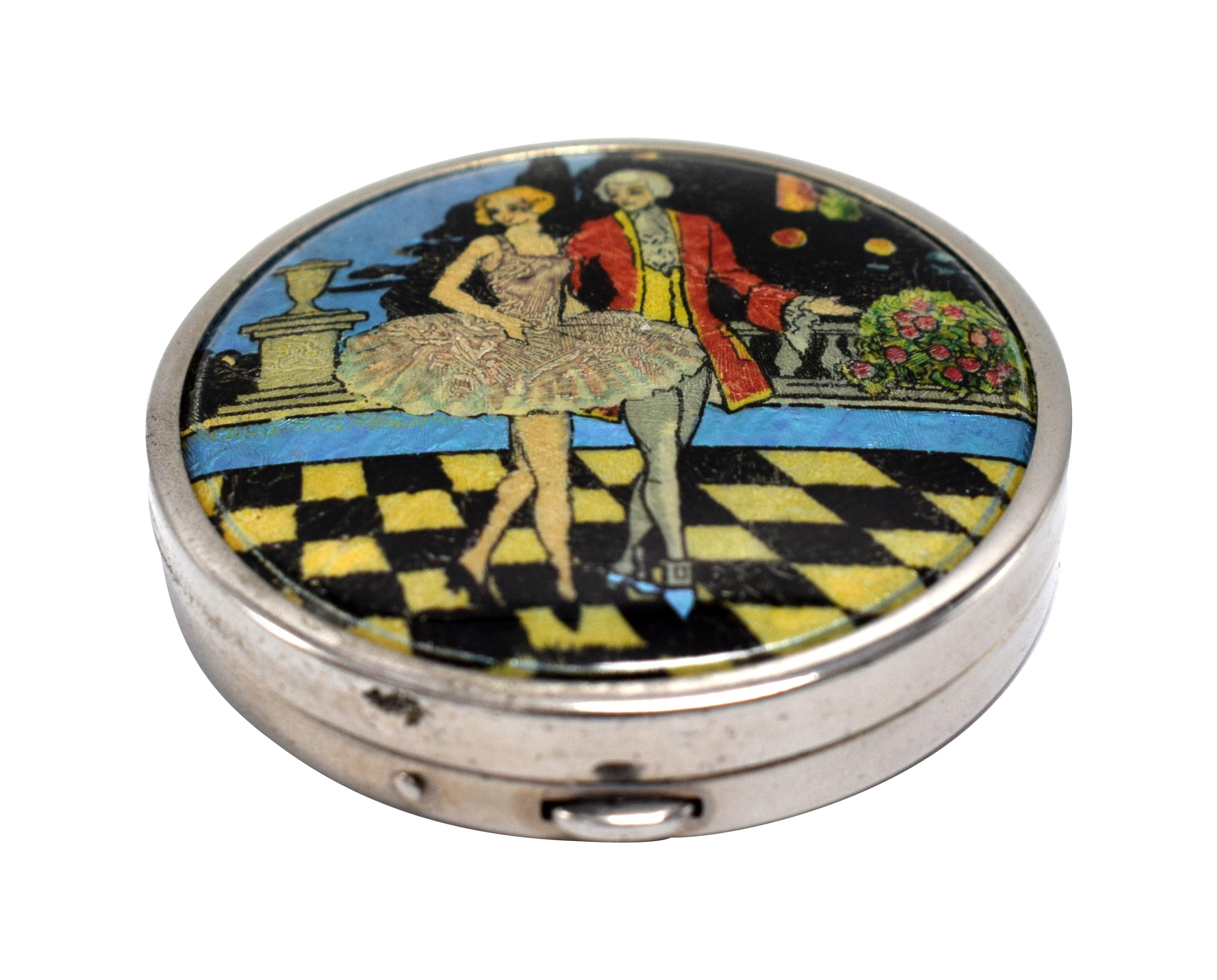 A delightful ladies Art Deco foil 'Tap flap' powder compact originating from England. The back is engine turned with the words ' Ladyn Fayne ' Made In England. The lid depicts a wonderful romantic scene of a young lady with her beau stood holding