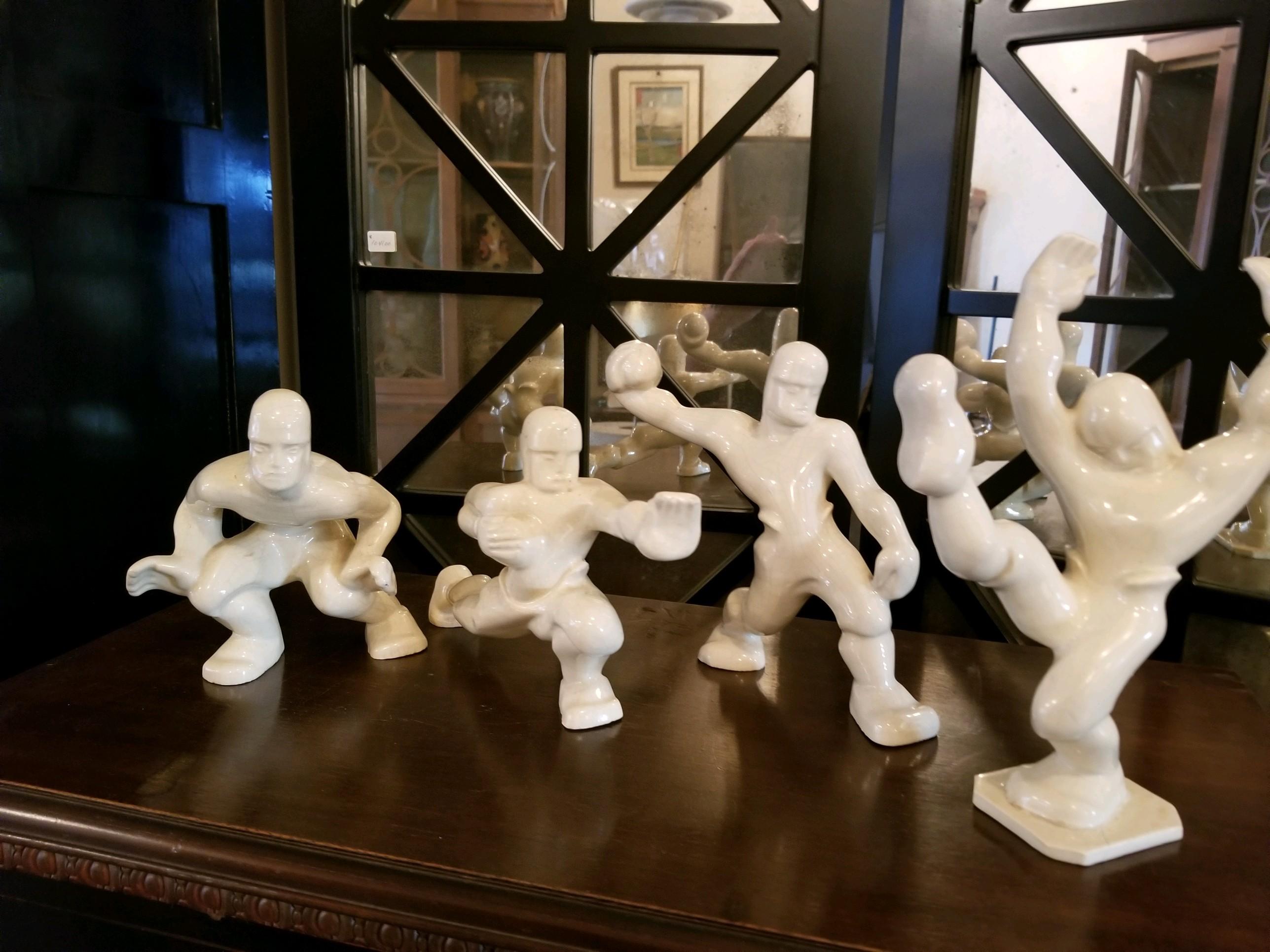 A rare collection of four Art Deco football players. They are in craquelure and in good condition rarely kept intact or together, these pieces are in good condition. I have noticed a fine hairline in one of the upward arms. It has been examined by a