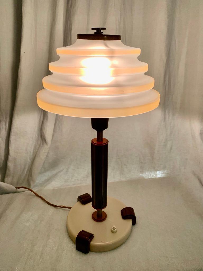 Extremely elegant Art Deco table lamp in bakelite, brass and glass. Manufactured by Danish LYFA in the 1930s. Curvy glass shade with powder colored stripes.
