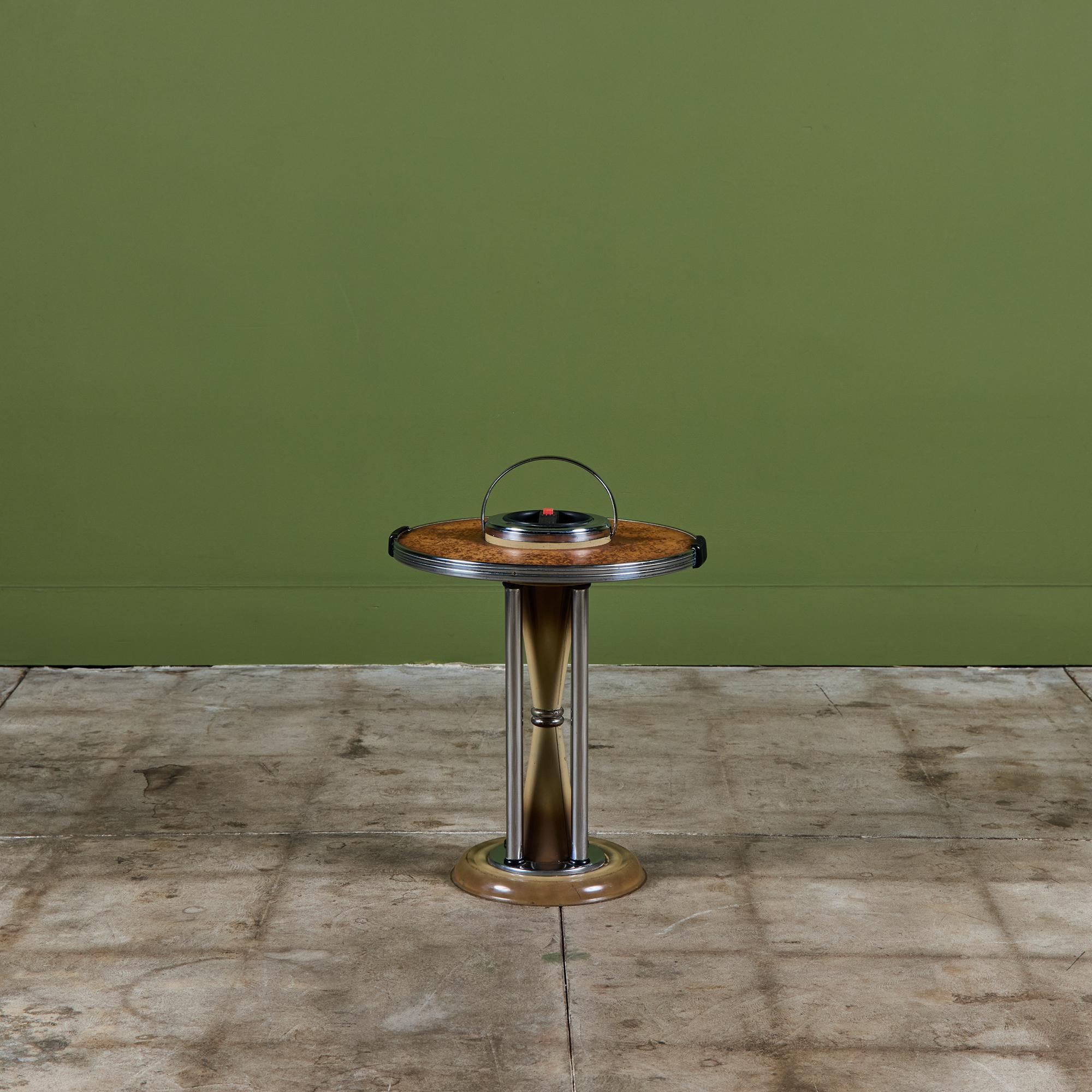 Art deco free standing ashtray c.1930s, USA. It features a wood laminated table top and stainless steel chrome body. The ashtray has a red button that opens as a 'trapdoor' to brush away ash. The stem on the table has an hourglass like shape