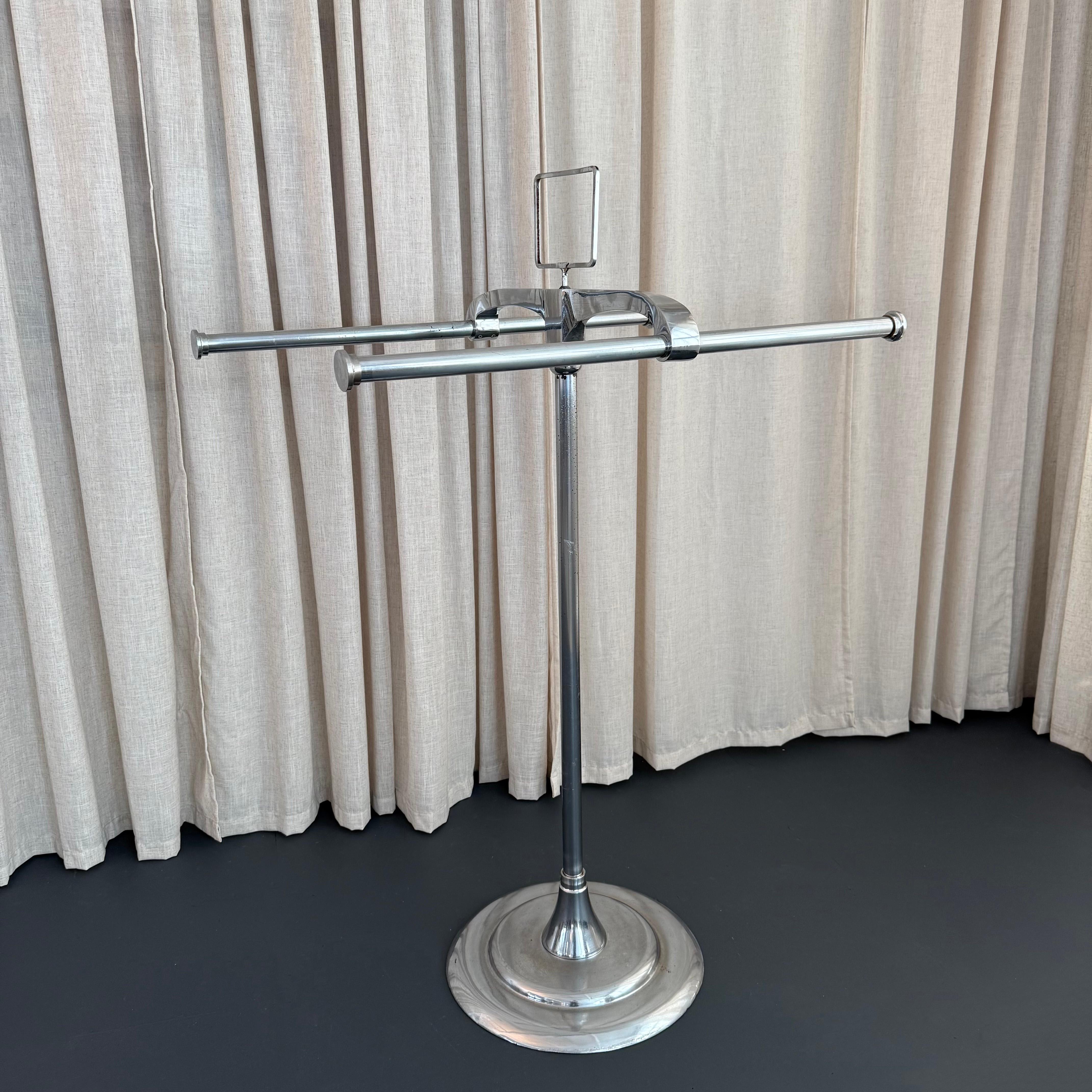 Questo bellissimo appendiabiti americano Art Deco, indipendente, in acciaio cromato e a doppio palo è il massimo del design futuristico dell'era Machin. La rastrelliera è dotata di due pali regolabili da 37 pollici per appendere gli indumenti,