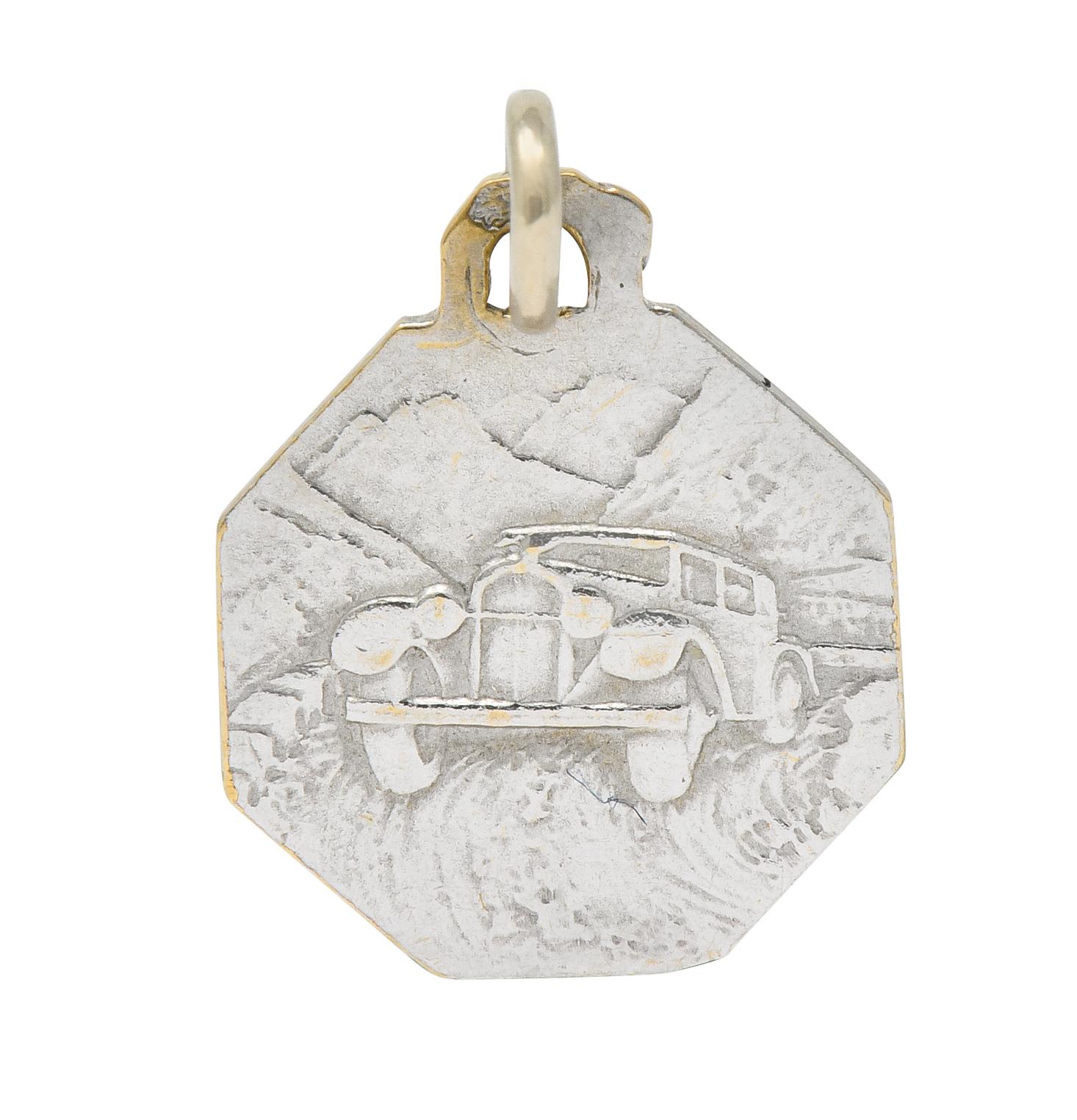 Octagonal charm depicting a highly rendered image of St. Christopher carrying child Christ

Reverse side depicts a 1950's style car driving through a mountainous valley

Completed by jump ring bale

With French assay marks for 18 karat