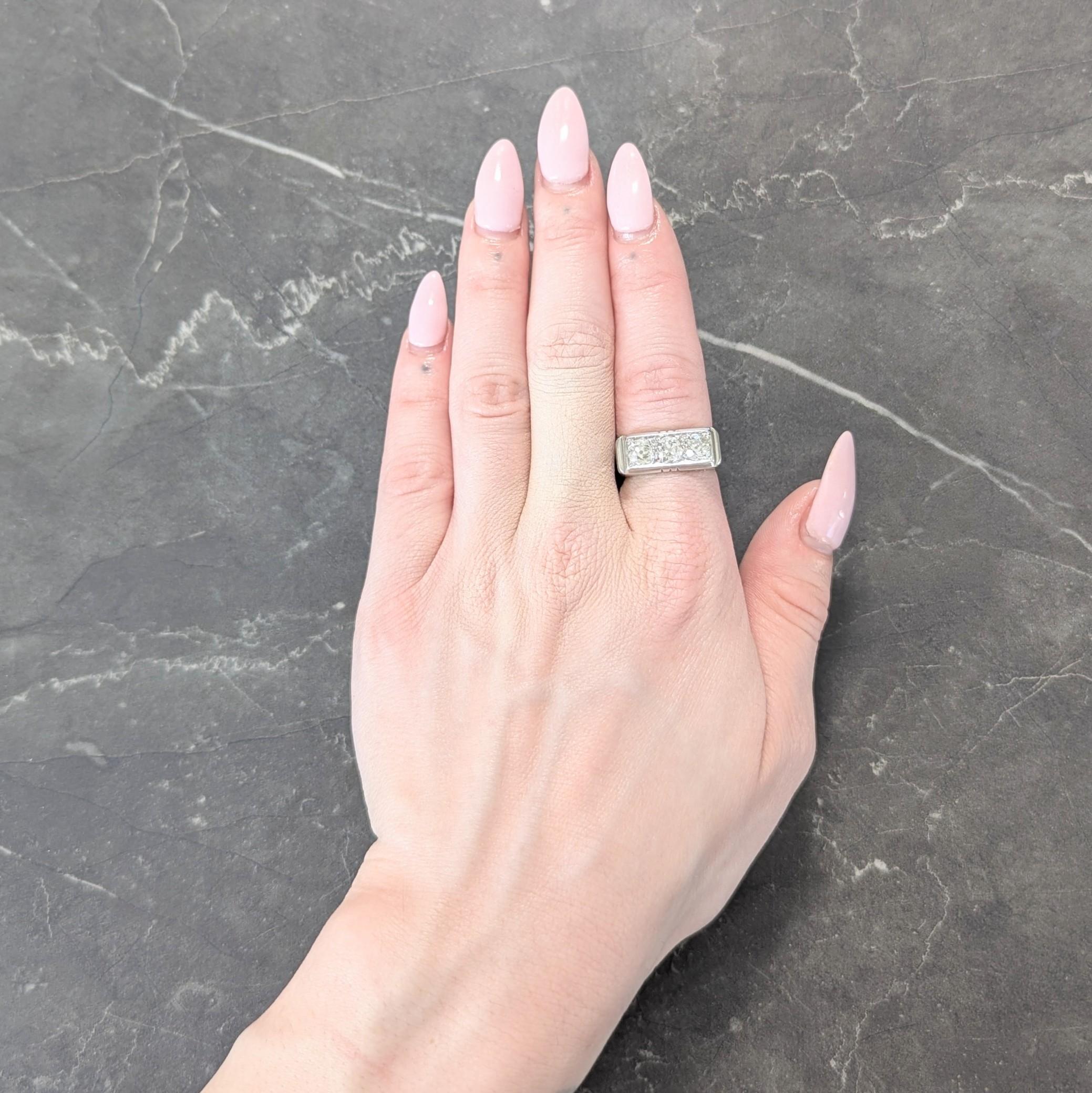Centering an elongated old mine cut diamond weighing approximately 0.75 carat - I color with SI2 clarity
Flanked by two additional old mine cut diamonds bead set east to west
Weighing approximately 1.30 carats total - L to N color with I1