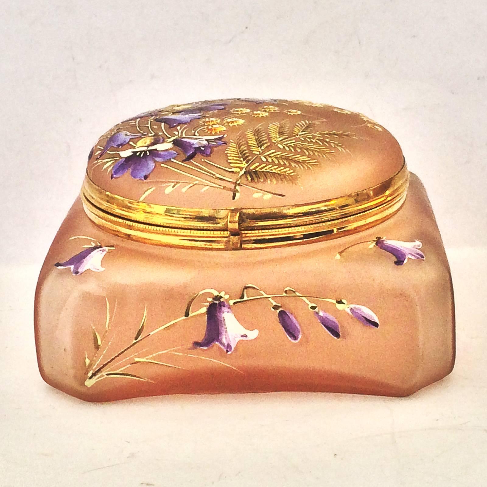 Art Deco, finely detailed Bonbonniere Box, brilliantly enameled in many colors, depicting Blue Bells, Ferns and sprigs of Golden little Daisies all on a pink glass ground. Probably by Daum of Nancy, or Montjoye. The Bluebells are also featured along