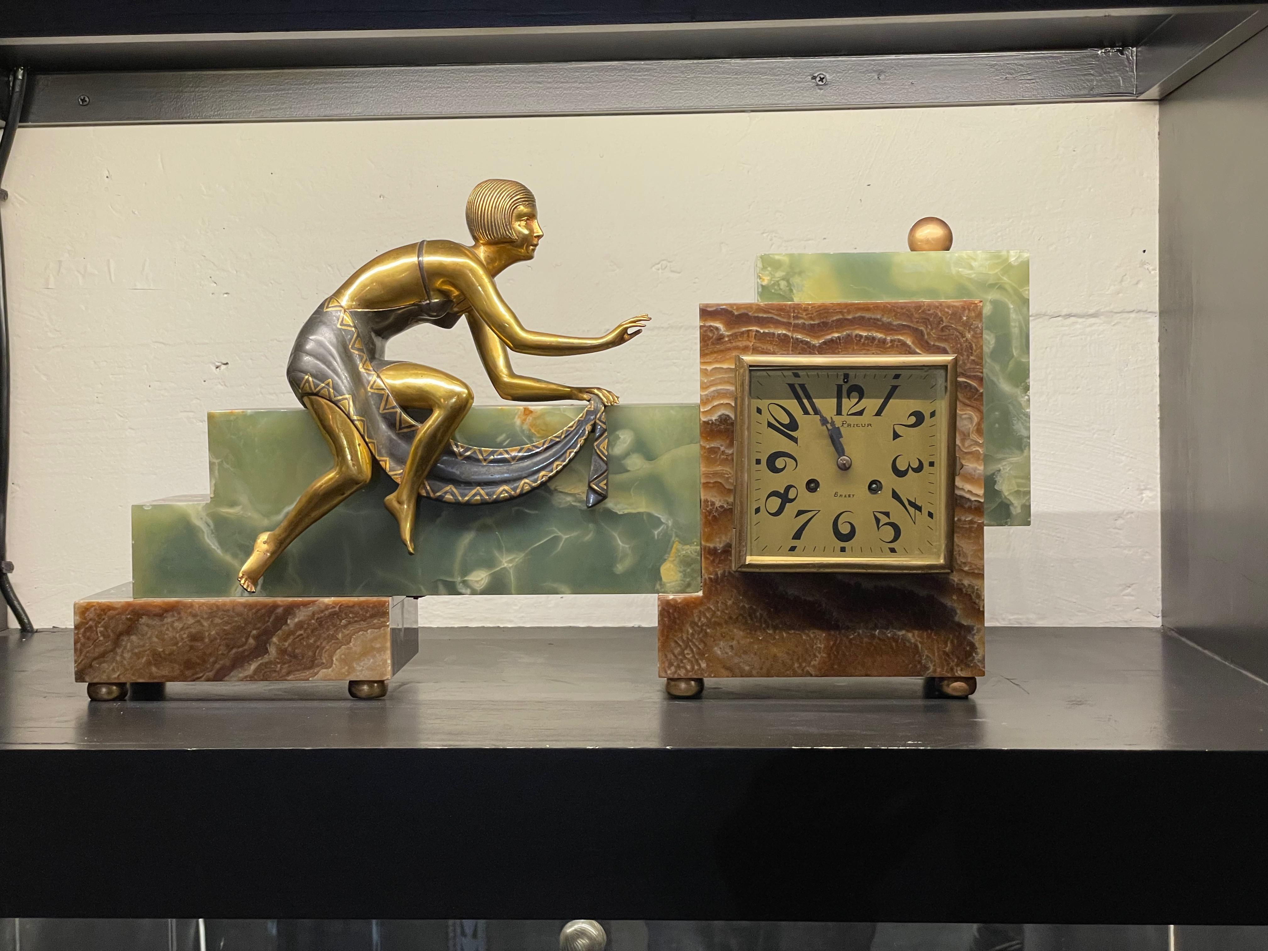 Art Deco French Asymmetrical marble clock with female statue. Rare clock design with amazing details. The woman who is sitting on top of the clock is in beautiful condition with her skin, shining in a gold patina but her dress is draped in a gray