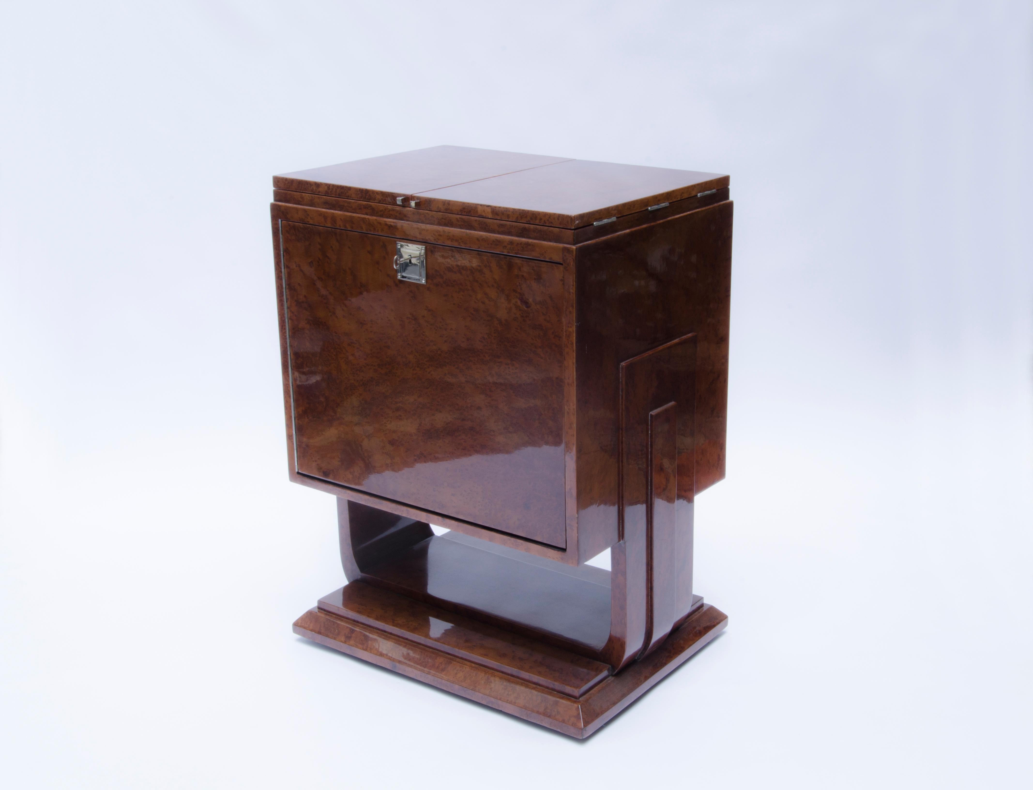 Art Deco bar veneered in maple root, with silver-plated bronze fittings and supports with mirror-lined interior and wheels. The glassware is Baccarat crystal.

France, CIRCA 1920.