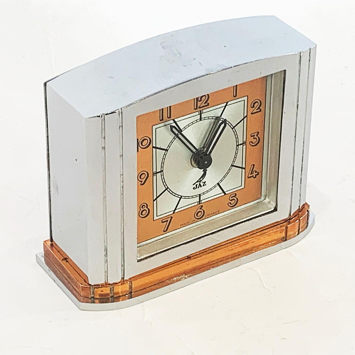 Art Deco French clock by Jazz. All in excellent condition, keeping good time and with a soft aged patina achieved from age. Satin chrome and copper face with black Arabic numerals, batons for minutes and “JAZZ” and the black crow, the company logo,