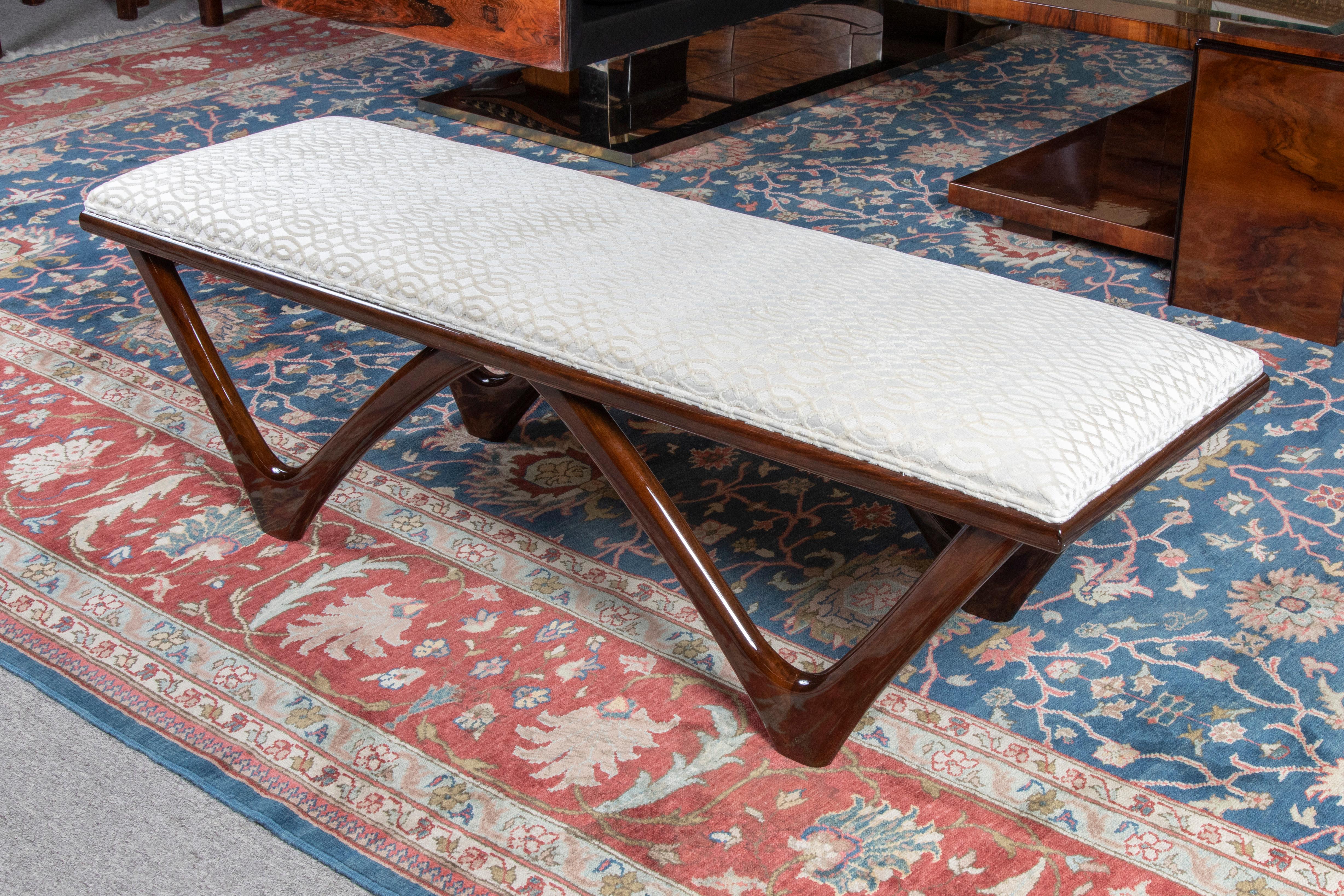 Art Deco French bench

Bench has wide rectangular seat, re-upholstered with light beige fabric. 
Bench is made out of fine Macassar wood.
Has 4 angular pointy wood legs,

French, c. 1930s
Condition is perfect. Restored. 
Measures: 55” x 18”