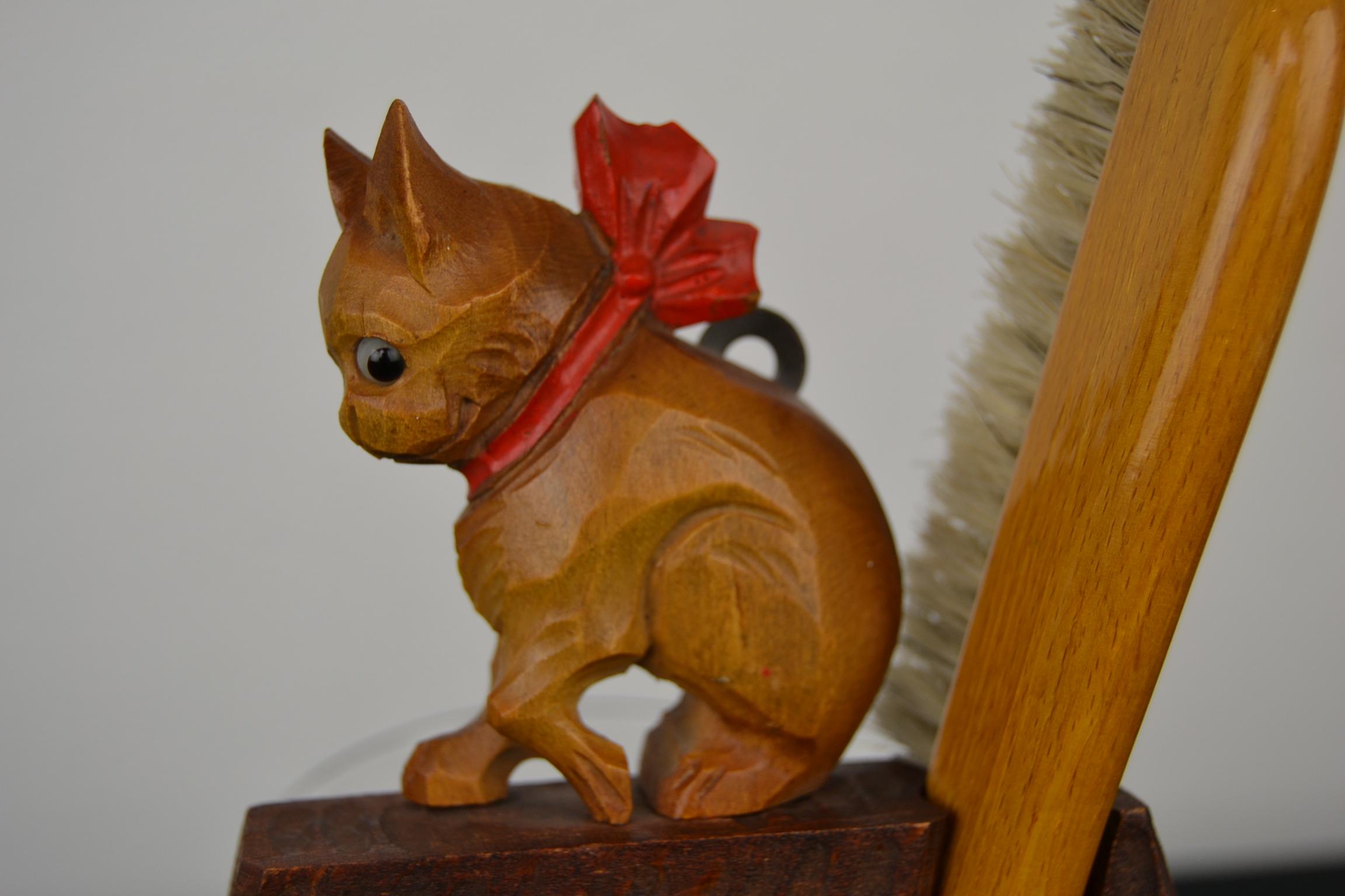 French bulldog crumb set, brush set.
This two-piece wooden set consists of a crumber or brush with a dustpan.
This antique tool for table-top crumbing has a cute French bulldog sculpture on top with a red bow around his neck. There is also a hook