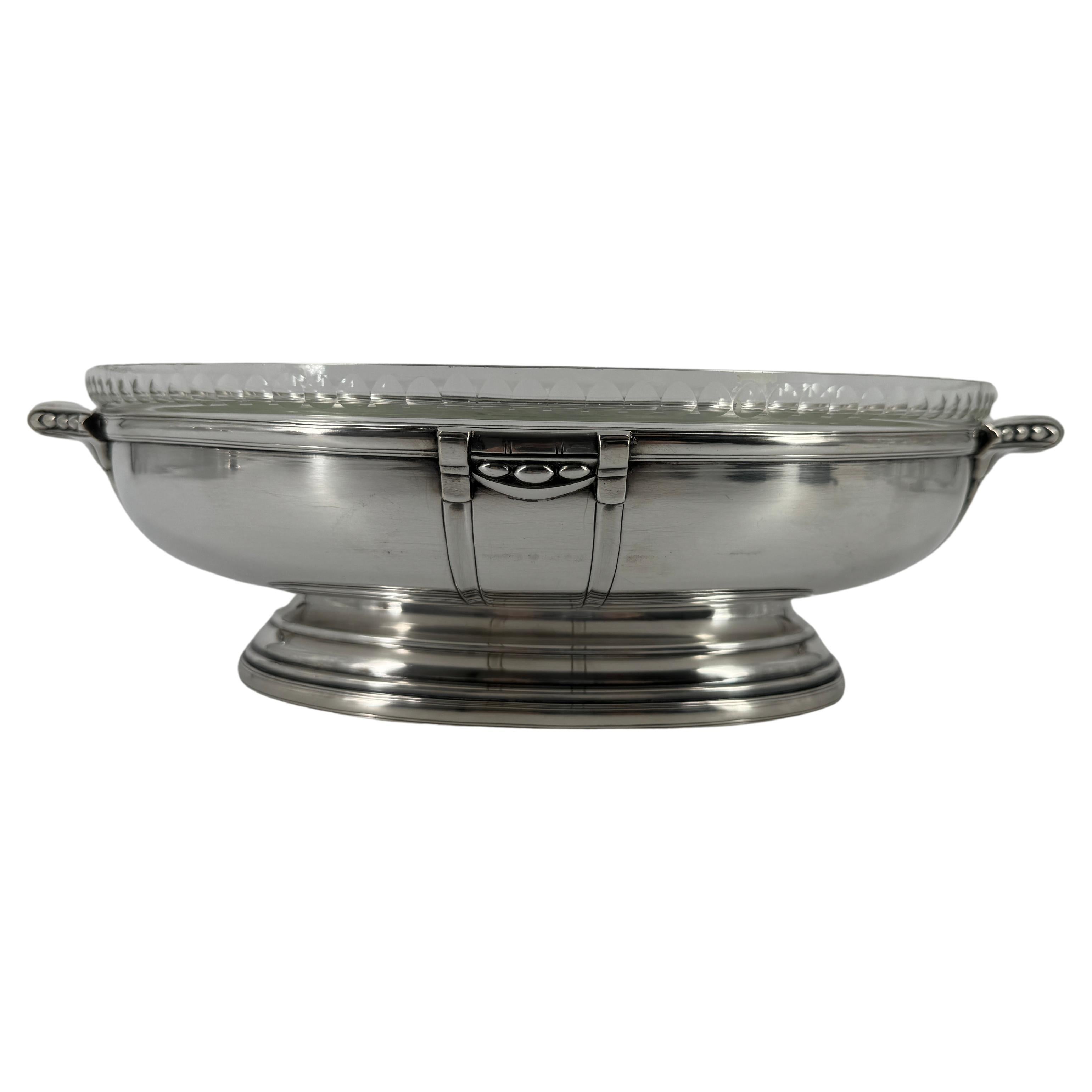 Attributed to Sue et Mare this art deco centre piece is composed of a silver plated oval recipient, and its original cut cristal liner.

The decor is a beautiful example of the French art deco period, circa 1925, and typical of Sue & Mare delicate
