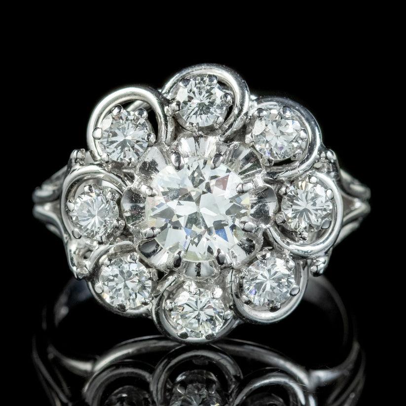 A magnificent French diamond cluster ring from the early 20th Century boasting a striking old european cut diamond in the centre weighing approx. 0.90ct with a halo of eight 0.12ct brilliant cut diamonds surrounding it (approx. 1.85ct total).

Each
