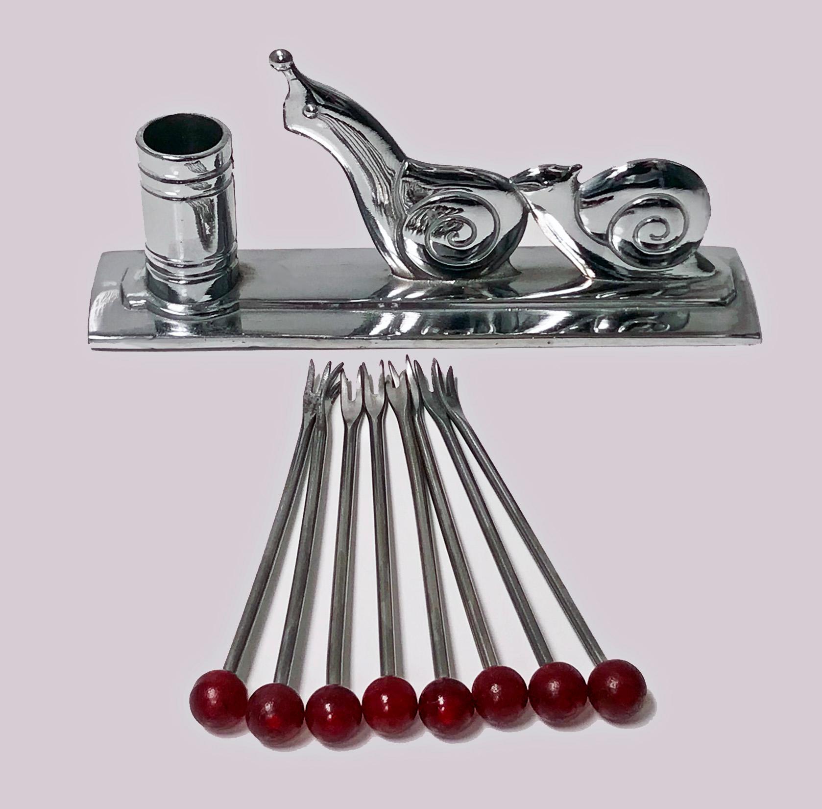 Art Deco French chrome cocktail set designed by Benjamin Rabier, circa 1930. The mount in the form of escargots with eight red Bakelite handle cocktail sticks. Measures: 5.0 x 1.20 x 2.25 inches (4.0 including sticks).