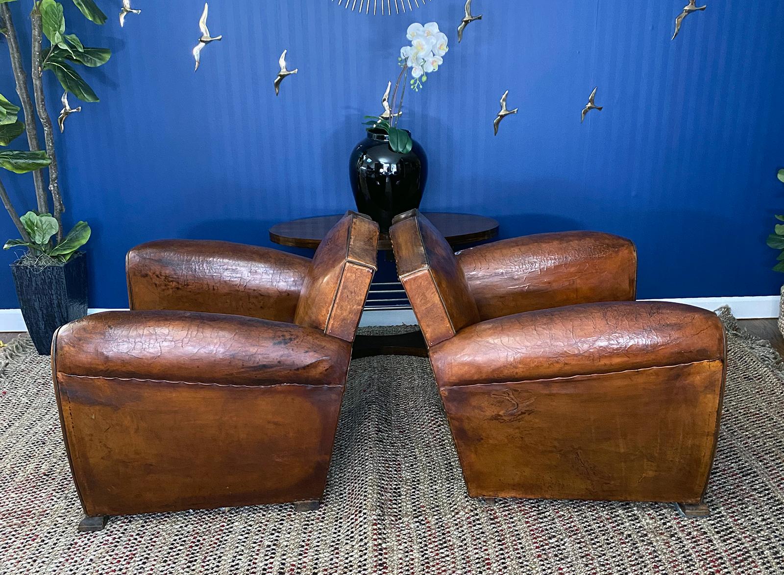Pair of moustache original Art Deco French leather club chairs, circa 1930s with spectacular soft and supple original leather. This is a beautiful, highly coveted moustache clubs pair with a lot of character and charm. Extremely comfortable. In very