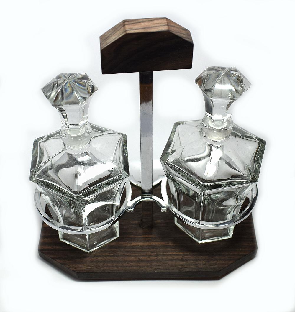 Very much in the style of Jacque Adnet is this wonder 1930s Art Deco condiment set. The wooden base is a lovely exotic palisander, part of the Rosewood family. A simple chrome frame holds two glass bottles for oils and vinegar. Lovely set in