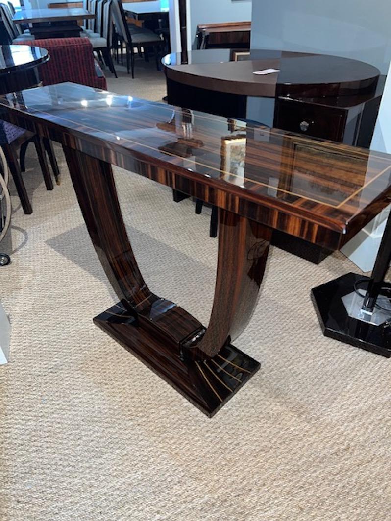 Beautiful and elegant Art Deco French console made out of Macassar wood. Top displays wood grain and elevated by the 2 semi-circular legs that are connected in the middle. Supported the the rectangular base.

Condition is perfect. Restored
France,