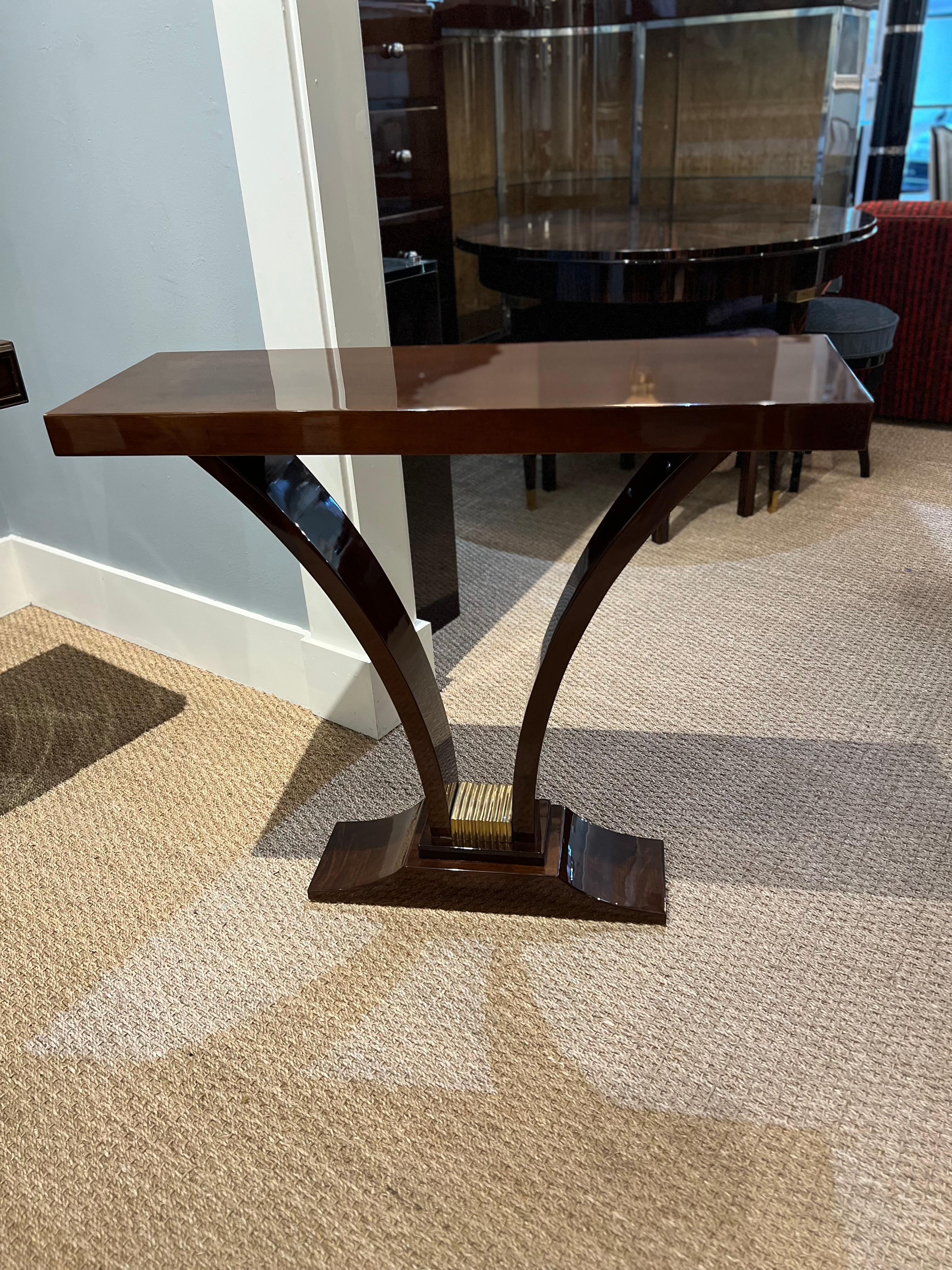 Elegant Art Deco Console from France is made out of high quality walnut wood. Console top is presenting beautiful wood grain. Elevated by the 2 curved inwards legs and attached to the trapezoid base. It the middle of the base is brass decorative
