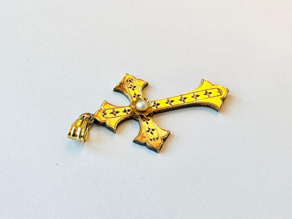Dieser Kreuzanhänger wurde zu Beginn des 20. Jahrhunderts in Frankreich hergestellt. Die Arme dieses Kreuzes enden in der Form einer heraldischen Lilie, und als Verzierung ist auf der Vorderseite eine weiße Perle auf einer Blume zu sehen.
Die