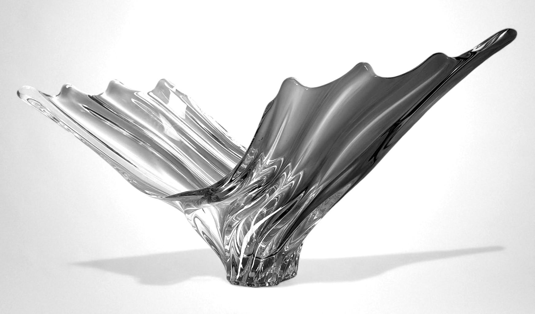 Exceptionnel et important centre de table en cristal de plomb dans un cristal clair et transparent. Sa silhouette allongée et audacieuse, définie par des courbes fluides et des extrémités doucement arrondies, capte le regard par son élégance