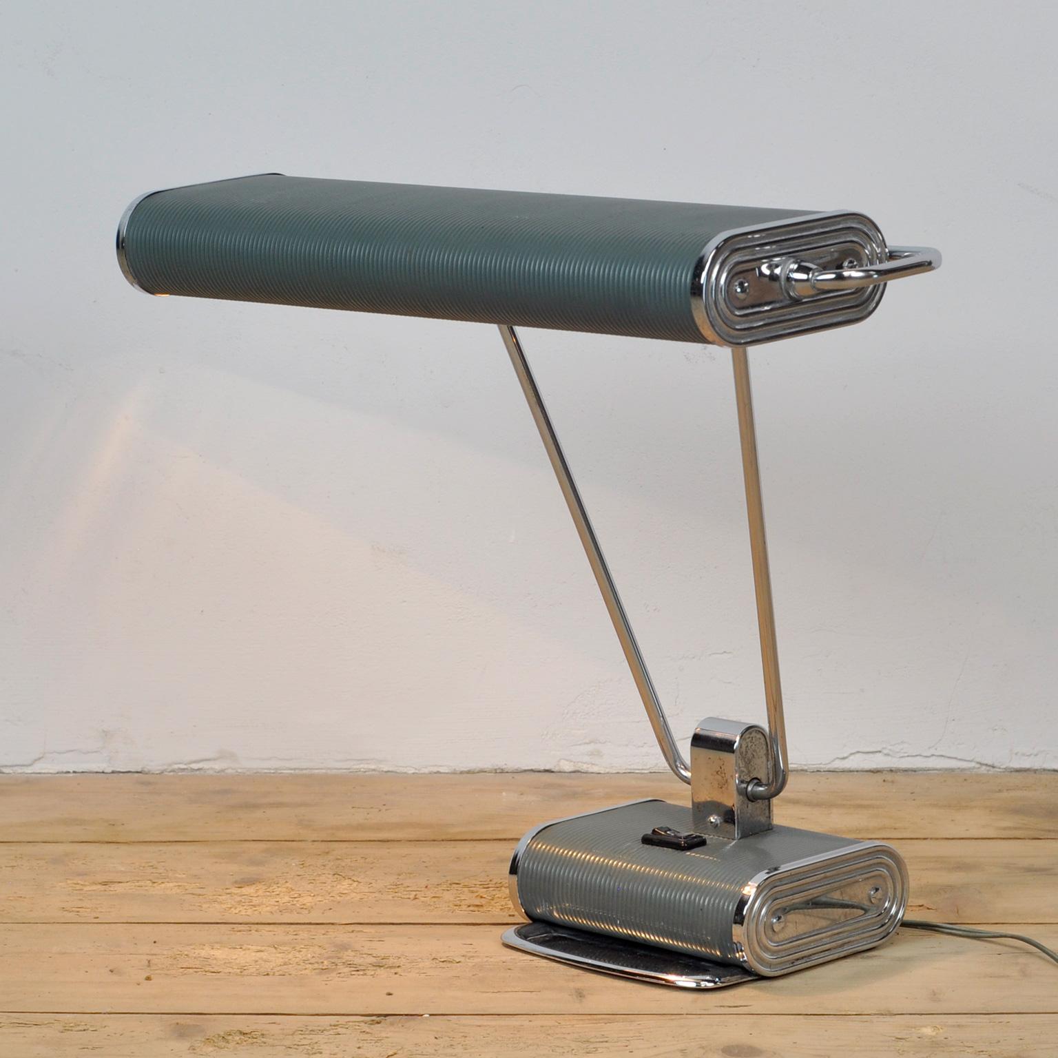 Lamp for Jumo in France circa 1950. The lamp consists of corrugated steel and the original grey-painted and chromed brass pipe. The long double arm can be tilted forward as well as backward and the wide reflector screen can be turned around its own