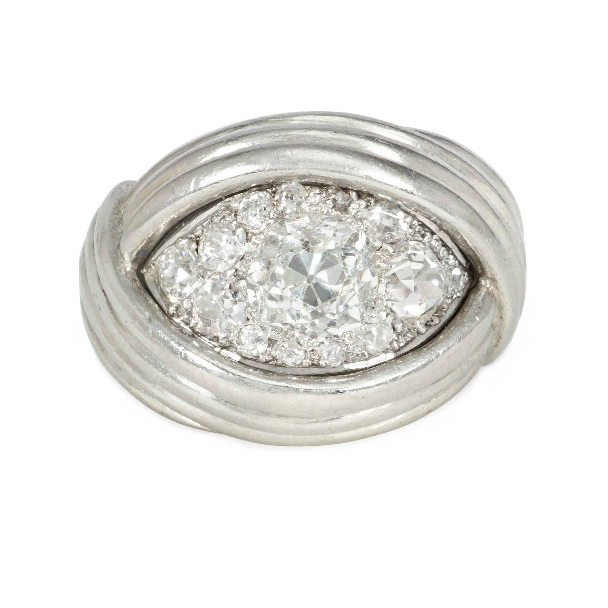 An Art Moderne diamond turban ring of wrapped bypass design with ribbed detail, in platinum.  France.  Atw 1.66 cts. (center stone is approximately 1.06 cts.)
Face up dimensions: 0.6