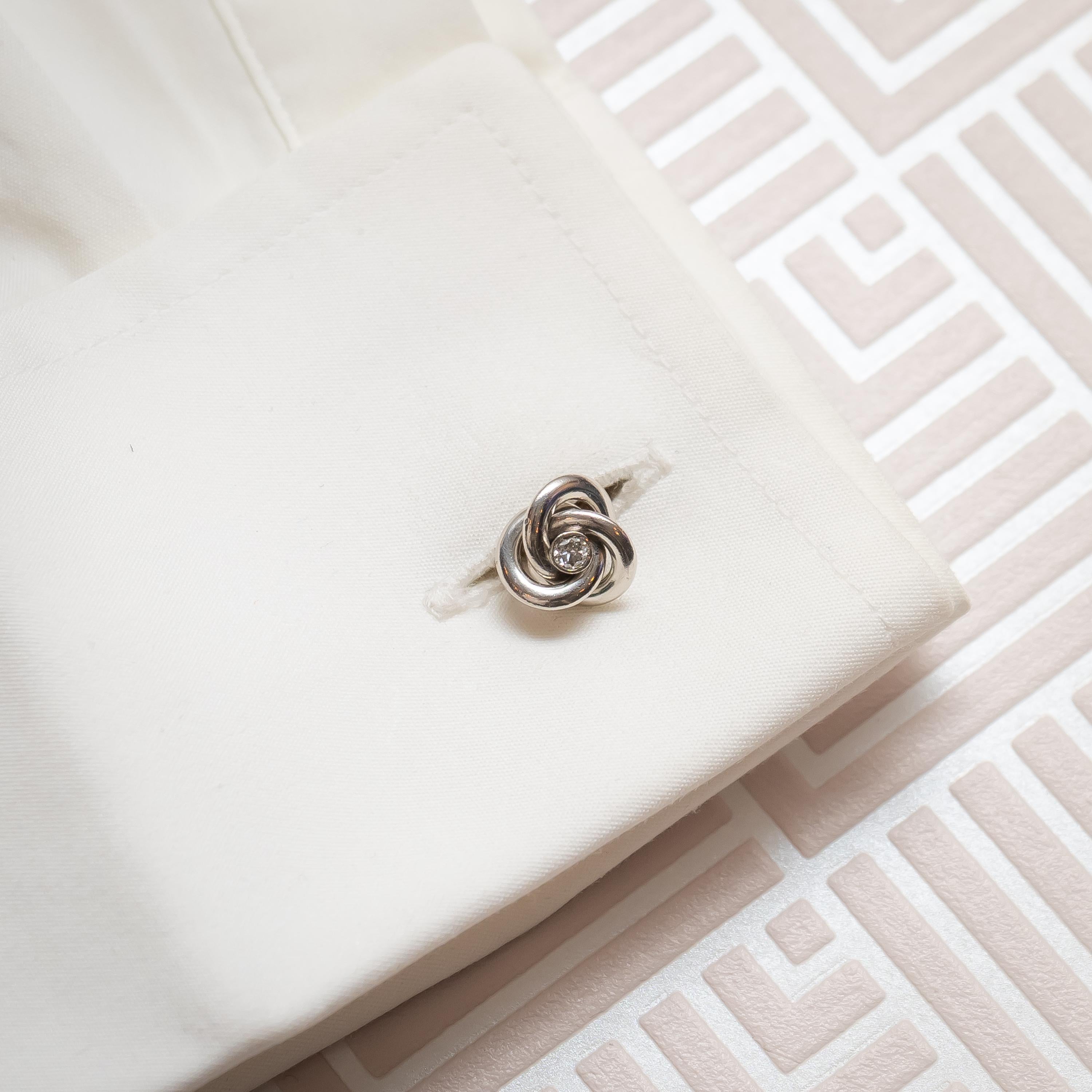 A pair of Art Deco, French, diamond knot cufflinks, with a central old cut diamond set in the centre of a platinum knot, on 18ct yellow gold fittings. Estimated total diamond weight 0.35ct. Head measures 10mm, fitting measures 18mm. Circa 1935.