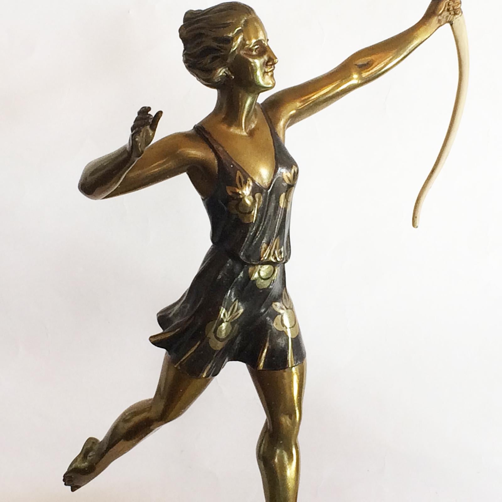 Art Deco French sculpture Diana “The Huntress” by Enrique Molins Balleste. In Fonte d' Arte, finished in gilt/bronze, cold painted dress and bow details. Mounted on brilliant rouge and white marble, with insets top and front triangle, of Green