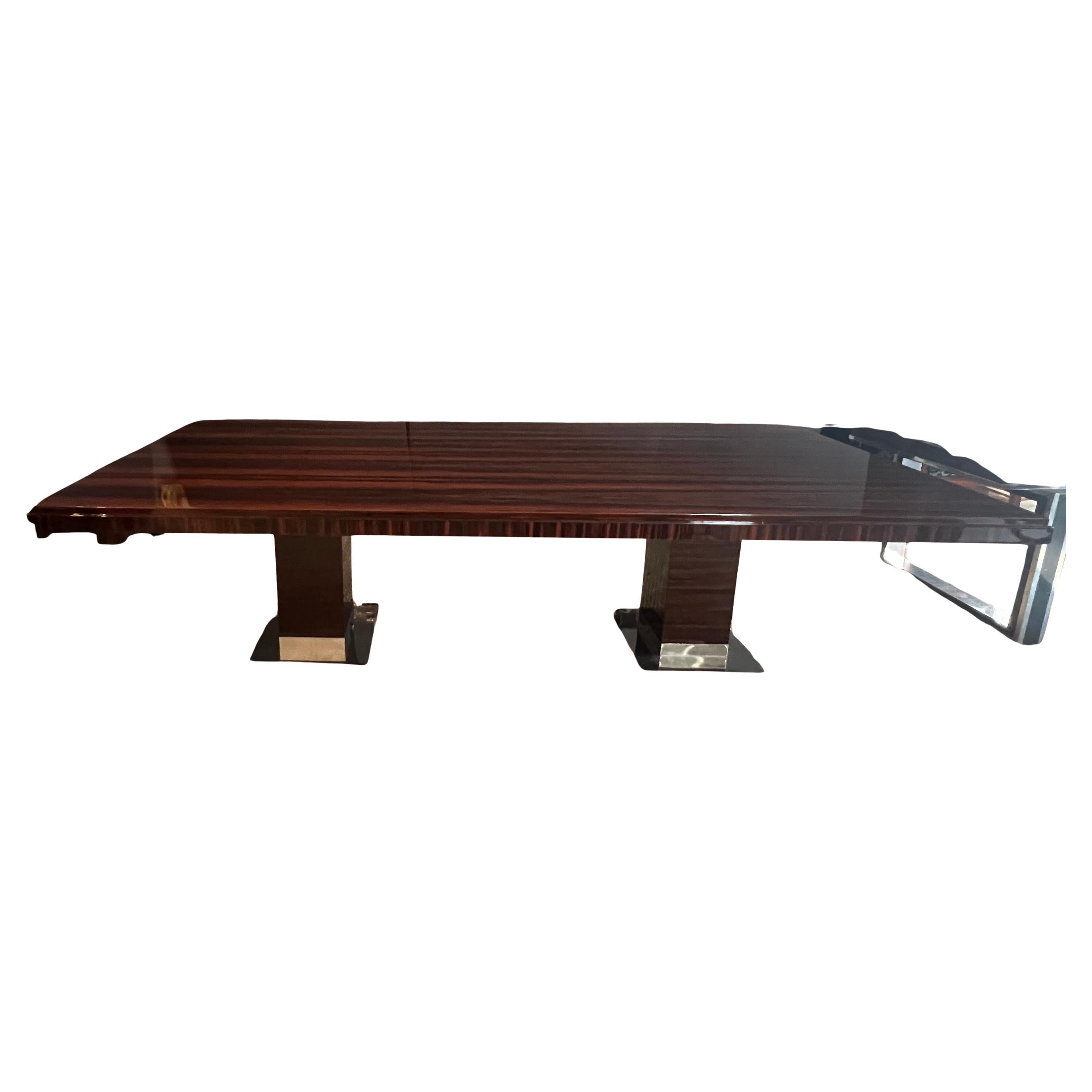 Grande table de salle à manger française de l'époque Art déco en bois de Macassar. Le plateau de la table présente de magnifiques veines de bois. La table repose sur 2 pieds rectangulaires et stables. Chaque pied est doté d'une base chromée. Le