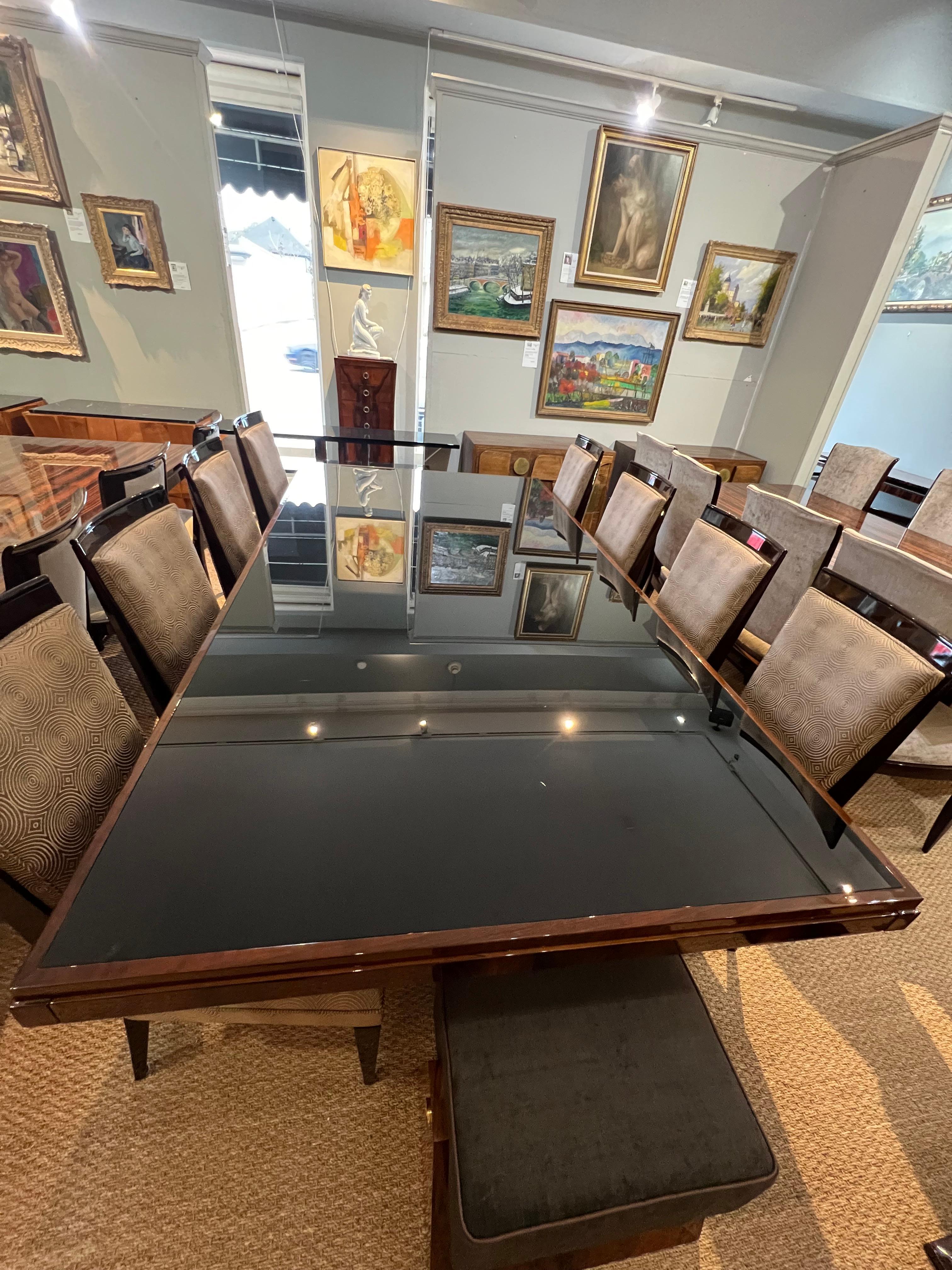 Grand Art Deco Dining Room Table made out of walnut wood. Table top is made out of glass, resting on 2 curved legs that are attached to the trapezoid base. Base is decorated with chrome decorative elements. Table top has 2 extensions on both sides,