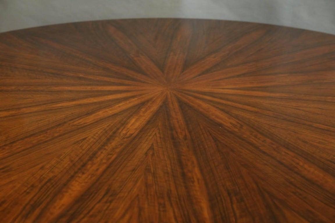 Dining room table is made out of high quality walnut wood and the highly polished tabletop displaying beautiful wood grain. The top is elevated by the four semi-curved legs, that are attached to the round stabile base.
Condition is perfect.