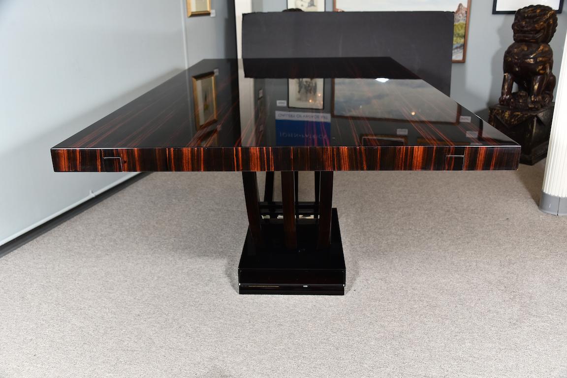 Table is done out of Macassar wood and table top displays a beautiful woodgrain. Top is connected to the small trapezoid base with 3 semi-circular legs. Bottom of legs are embellished with 3 decorative chrome brackets.
Table top has 2 extensions on