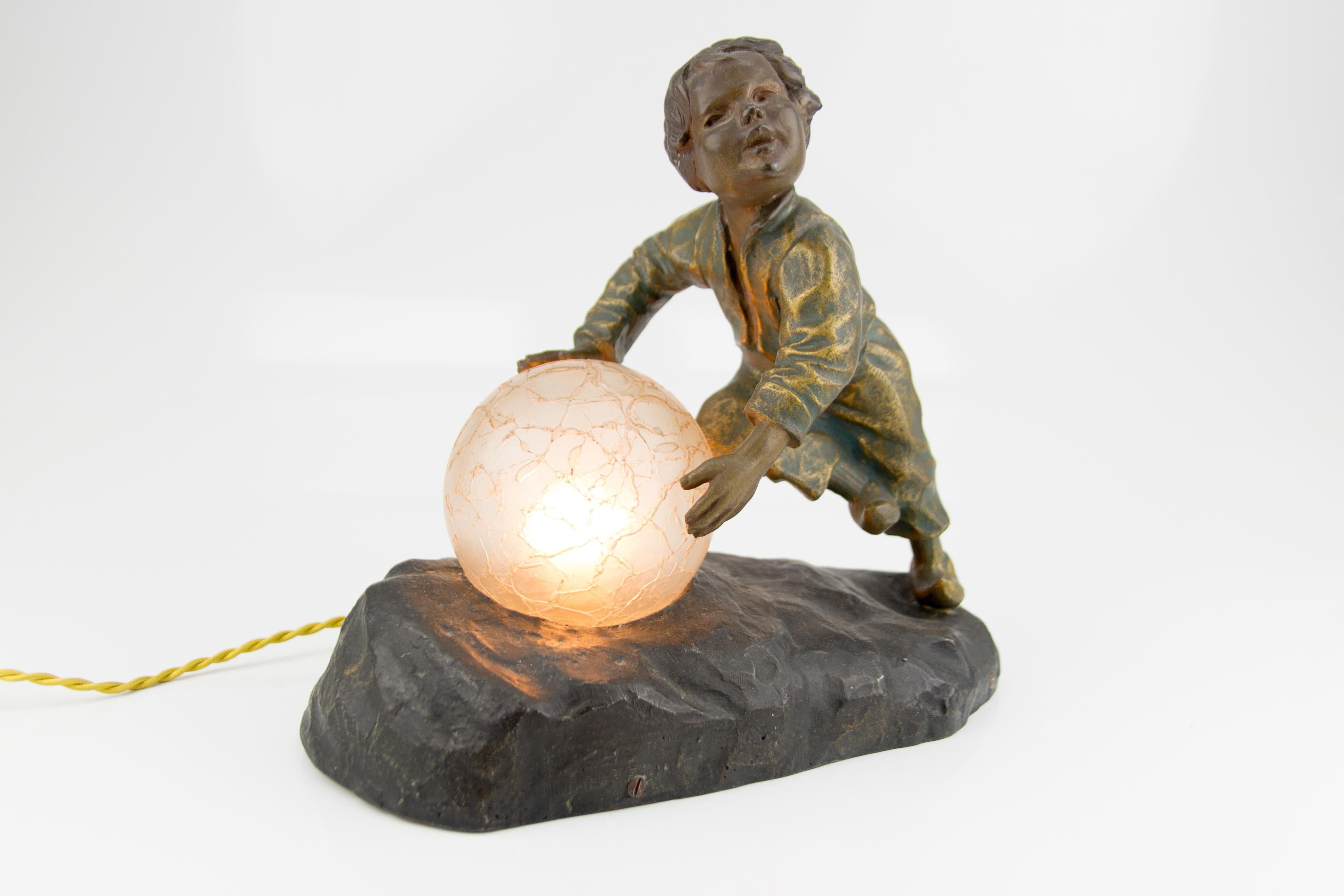 Very nice French bronzed spelter lamp of a boy pushing a snowball which is a crackle glass globe lampshade. Mounted on a spelter base, fitted with wood. Approximately from the 1930s, after Aristide the Ranieri (1865-1929; born in Italy, was active /
