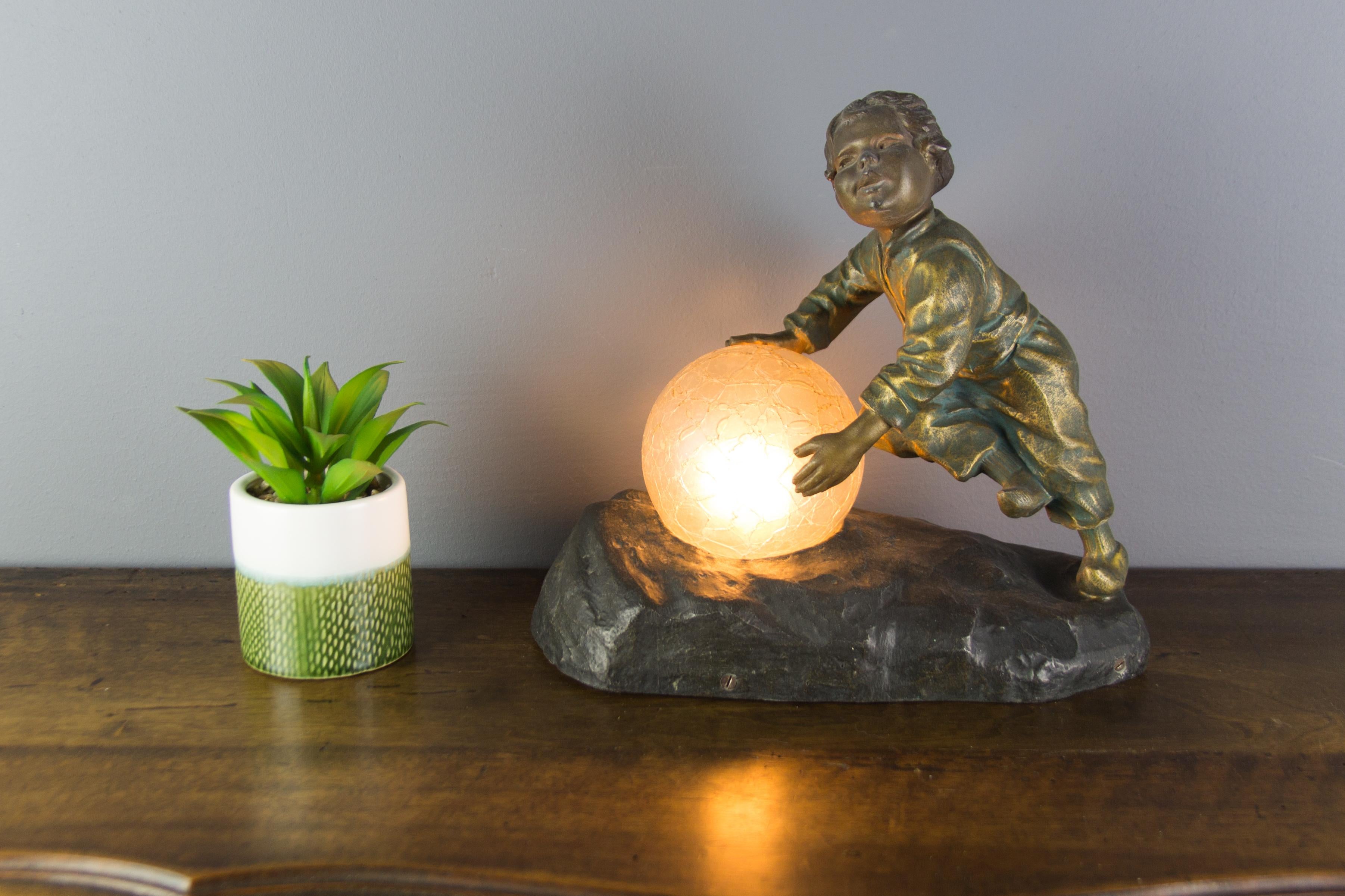 Mid-20th Century Art Deco French Figural Lamp Boy Pushing a Snowball Crackle Glass Globe Shade