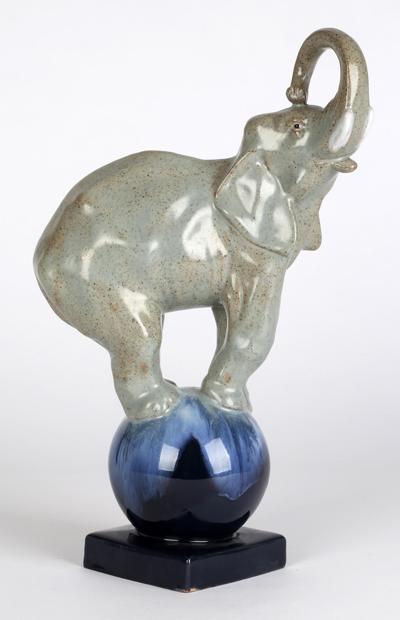 Une étonnante sculpture en poterie émaillée Art déco française représentant un éléphant de cirque en équilibre sur une boule, datant d'environ 1925. La figurine en terre cuite représente un éléphant en équilibre sur une boule arrondie montée sur un