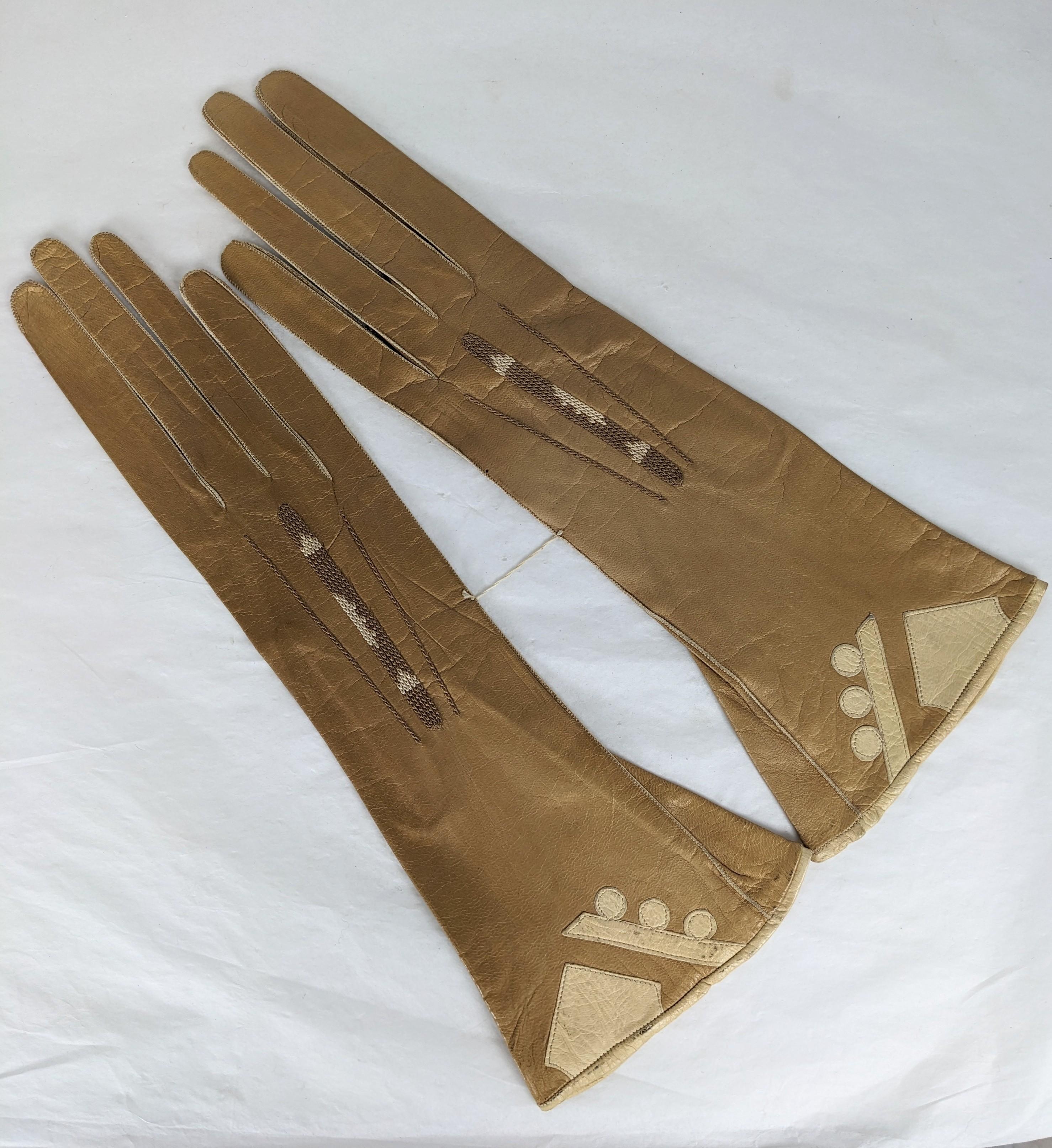 Charmante Art-Deco-Motiv-Lederhandschuhe, die nie getragen wurden. Sie sind immer noch so zusammengenäht, wie sie in der damaligen Zeit verkauft wurden. Art-Déco-Lederapplikationen am Bündchen und passendes Strickmuster am Oberteil. Zu winzig, um