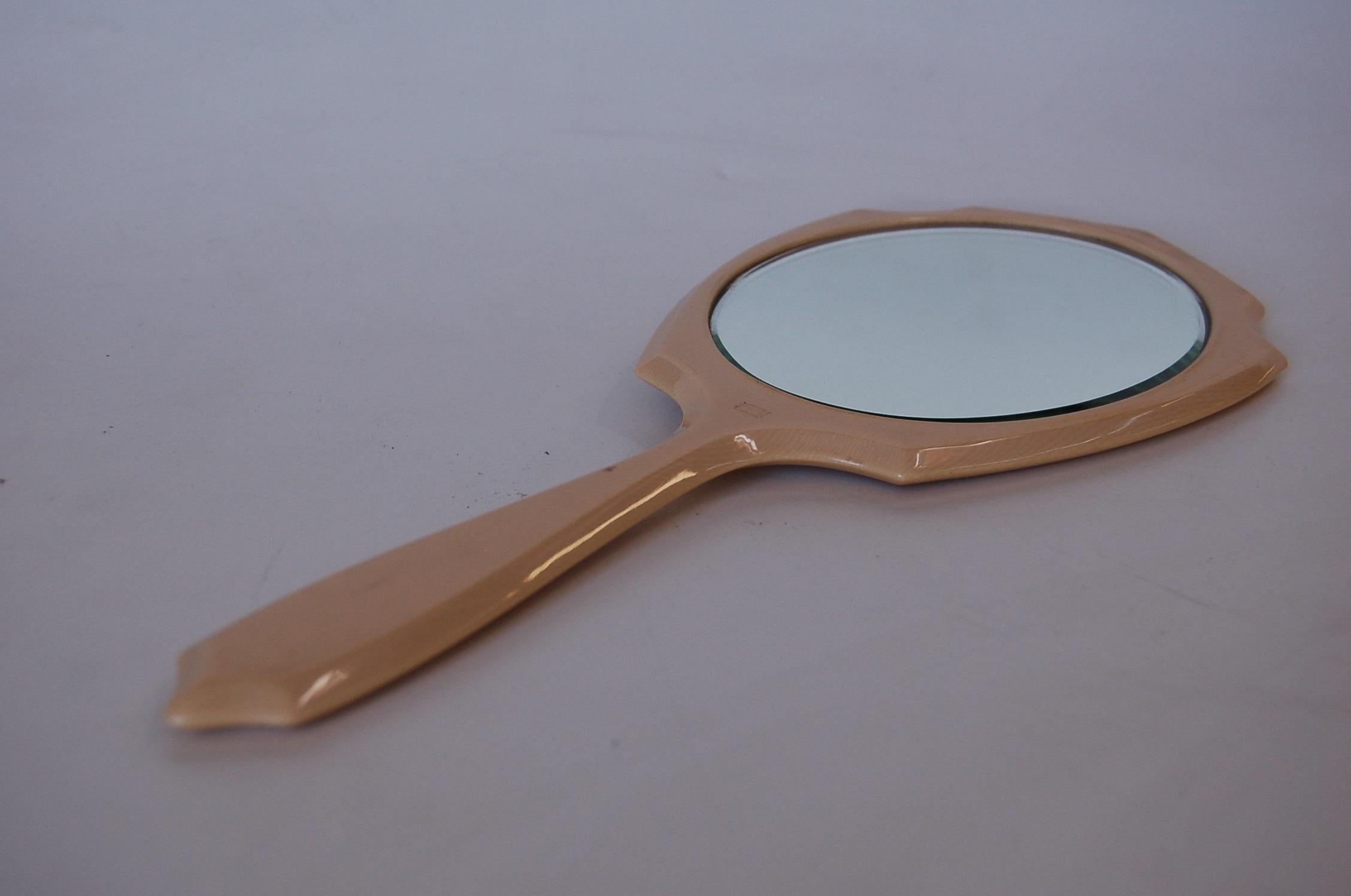 Modernist Art Deco celluloid vanity hand mirror.

Measures 18