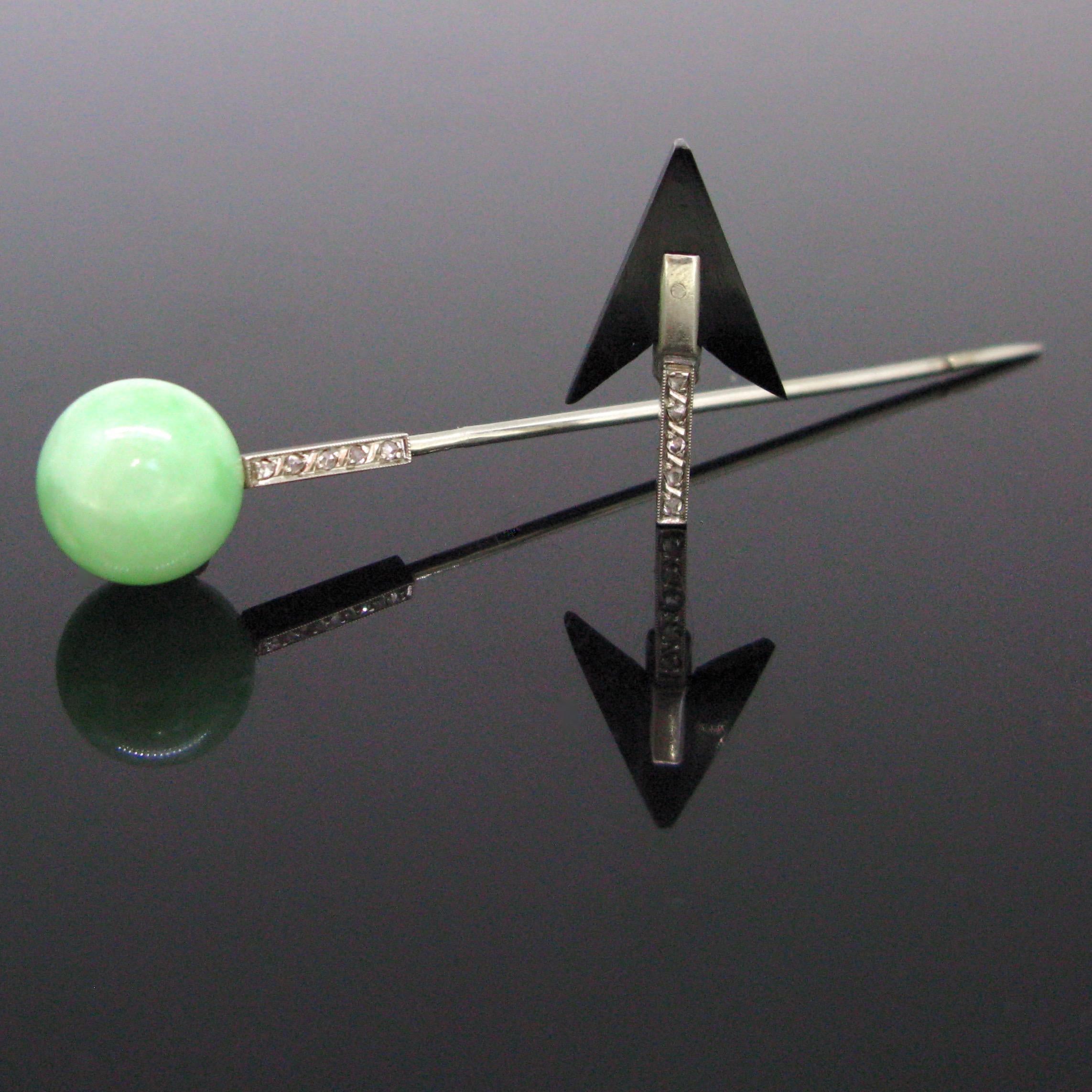 This stick pin comes directly from the Art Deco period. It is set with a bead of a jade jadeite and it ends with a black material arrow. The stickpin is made in 18kt white gold and it is adorned with rose cut diamonds. How refined is this. Actually,