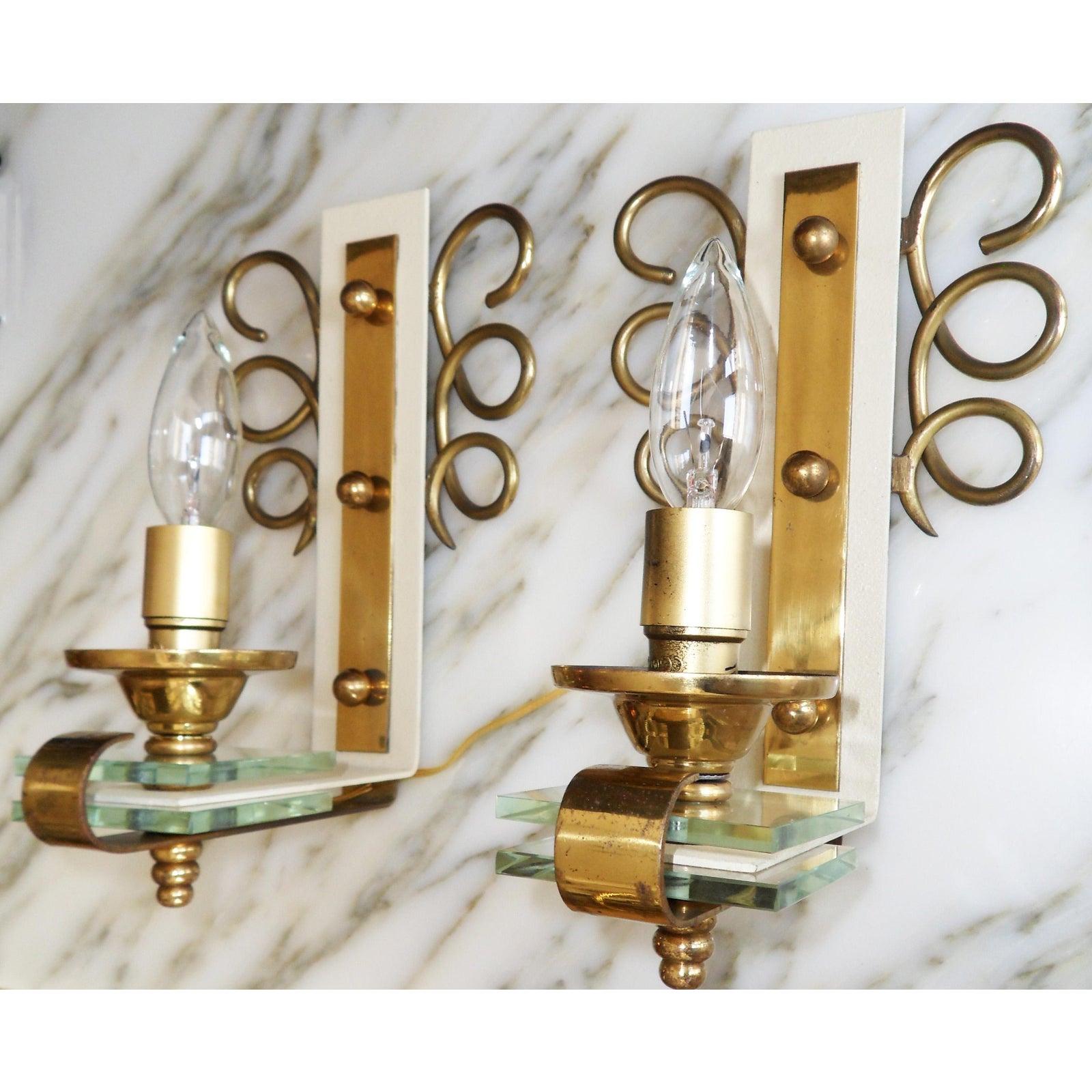 French Art Deco circa 1950 original pair of Jules Leleu  style sconces, brass and crystal.
Wired for US and in working condition each sconce takes one bulb max. 40 watts.
Original aged patina to the brass.
Sold with new black & gold paper