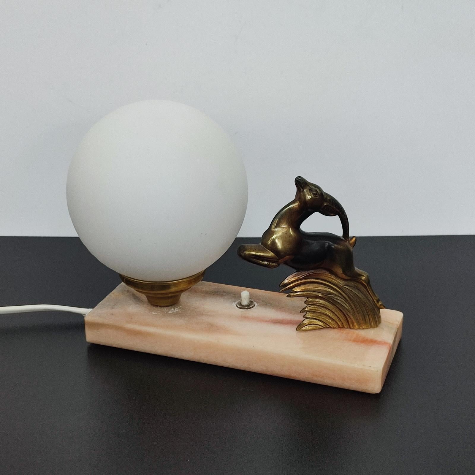 Art Deco table lamp or night lamp, jumping deer, white satined glass globe, on marble base.
Switch on the base. E14 light bulb. On request, we can replace it with E12for the US.
Good overall condition, few wear on the marble, light patina,