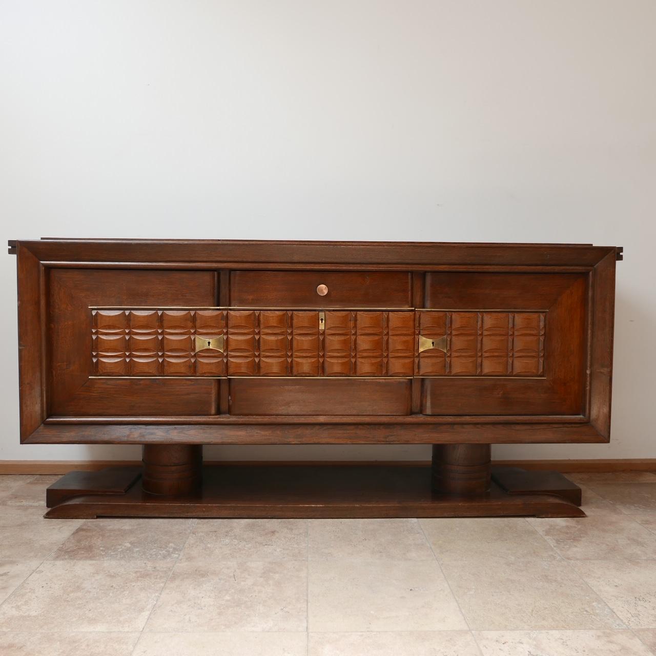 A large credenza or sideboard. 

France, c1930s. 

Art deco. 

Wooden, brass hard hardware. 

Good condition. 

Two doors on the left and right, the central strand has a drawer and drop down door cabinet. 

Dimensions: 220 W x 103 H x 54