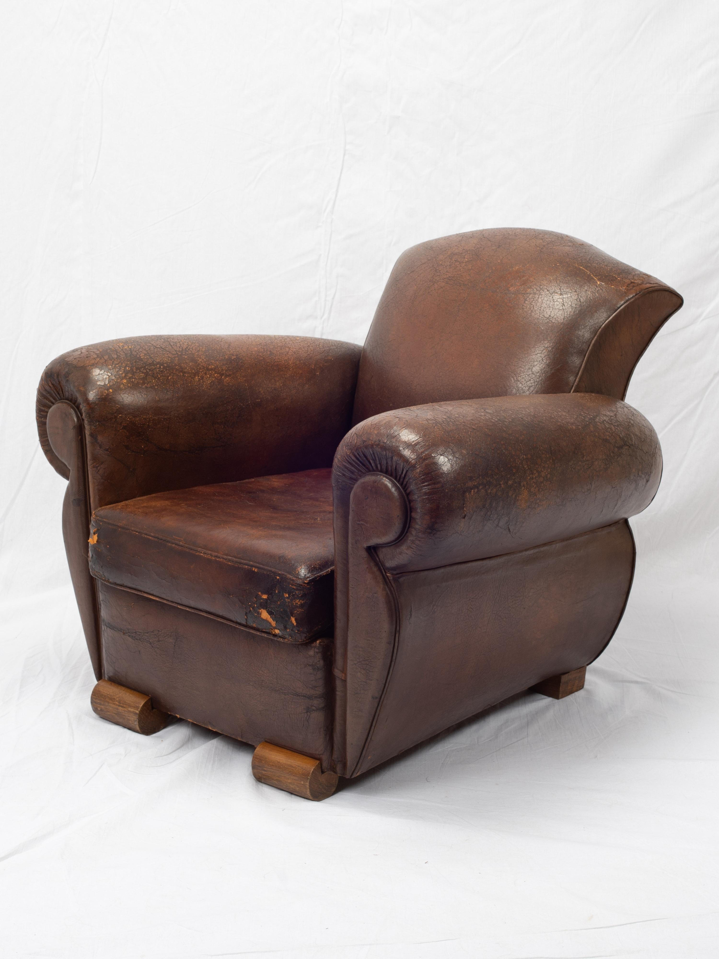 This is a classic mustache-style leather club chair from the first half of the 20th century. Likely created in the 1940s-1950s, this piece is an excellent, and somewhat unconventional, example of French craftsmanship. Sporting a wonderful deep, rich