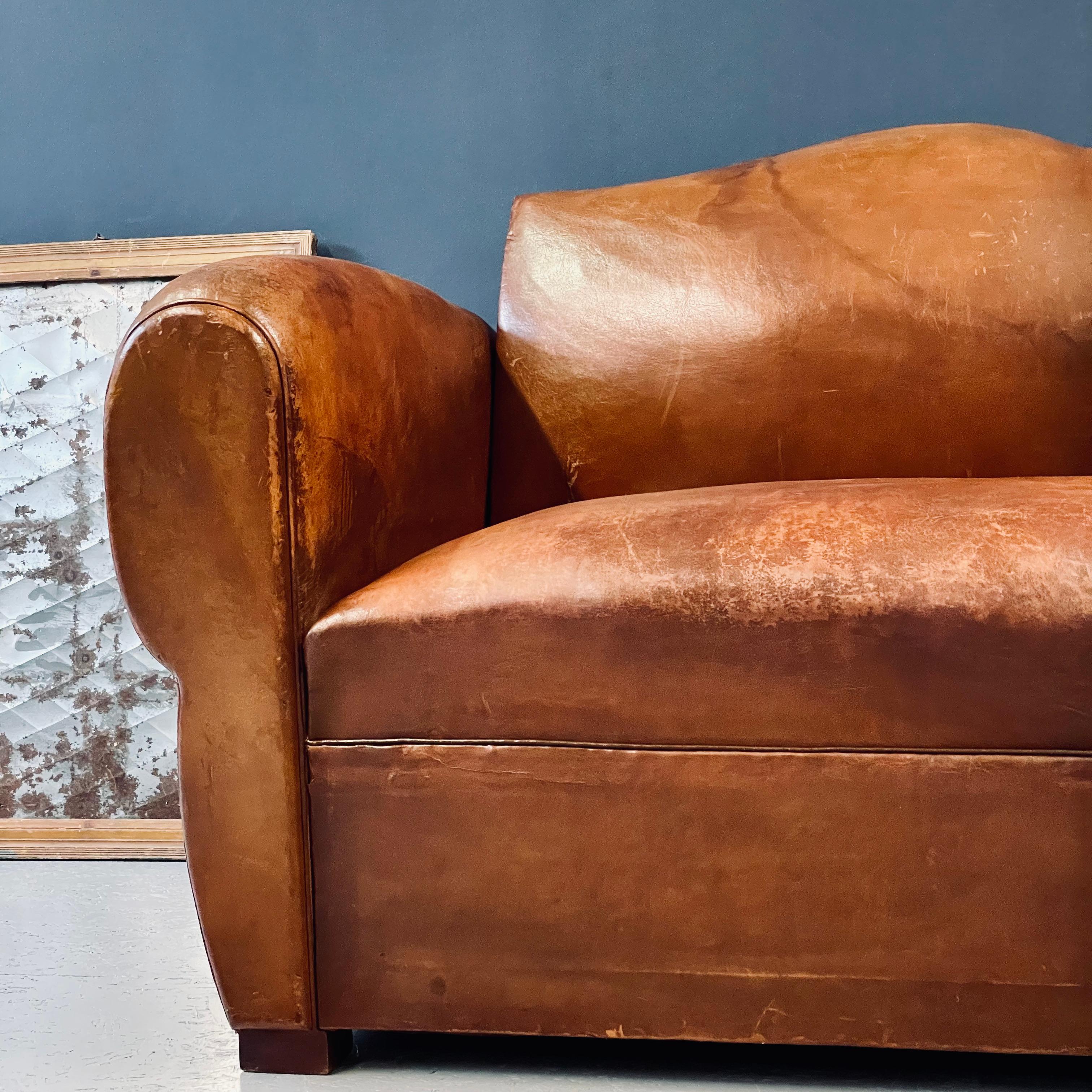 Mid-century French leather Moustache Club Sofa. This is a fully functional fold out sofa bed from the 1940`s. A two seater classic couch with retractable bed springs. The 70 year old leather has a wonderful patina but the piece does have signs of